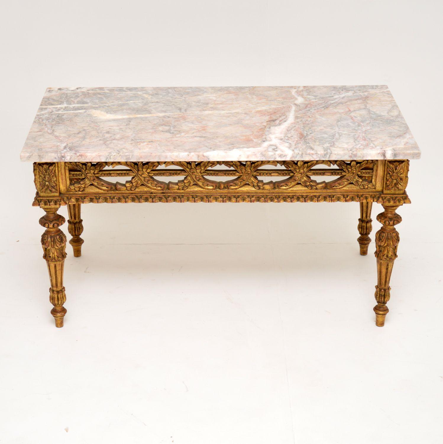 Antique carved giltwood coffee table with a loose marble top all in excellent condition and dating from circa 1920s period. The giltwood frame has pierce carvings all around the top and the legs too are well carved. It’s the original gilding, with