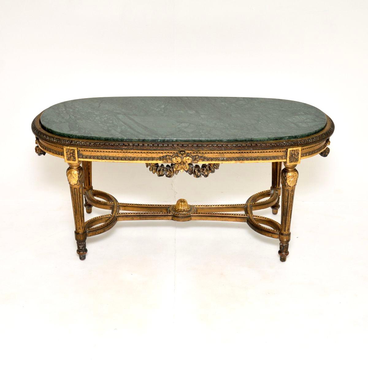 Superbe table basse ancienne en bois doré avec plateau en marbre. Fabriqué en France, il date des années 1930.

Il est d'une superbe qualité, le cadre en bois doré est orné de magnifiques détails sculptés sur tous les bords et sur la base étirée