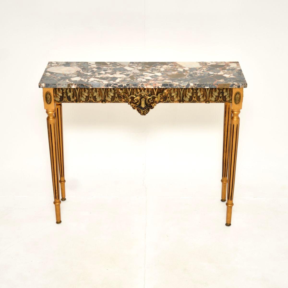 A beautiful antique French gilt wood marble top console table, dating from around the 1930’s.

This has a stunning design, the gilt frame is made from solid wood with ornate gesso mouldings. The marble top has gorgeous colour tones and patterns, it