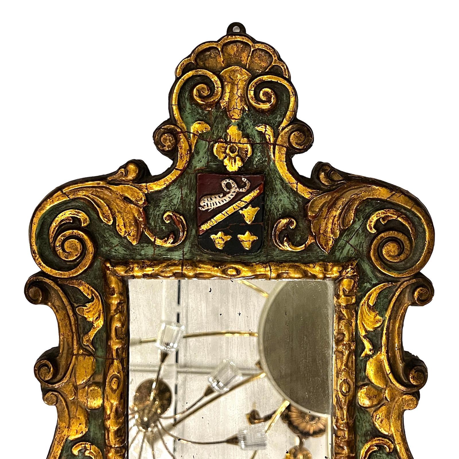 A circa 1920's French carved, gilt and painted mirror with crest detail.

Measurements:
Height: 25