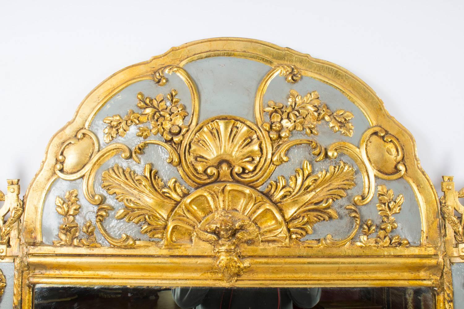 A large French carved ormolu, giltwood and grey painted overmantel mirror, circa 1860.
 
The shaped rectangular mirror has its original glass plate. It features a superbly carved giltwood and grey painted frame with ormolu mounts, the carved crest