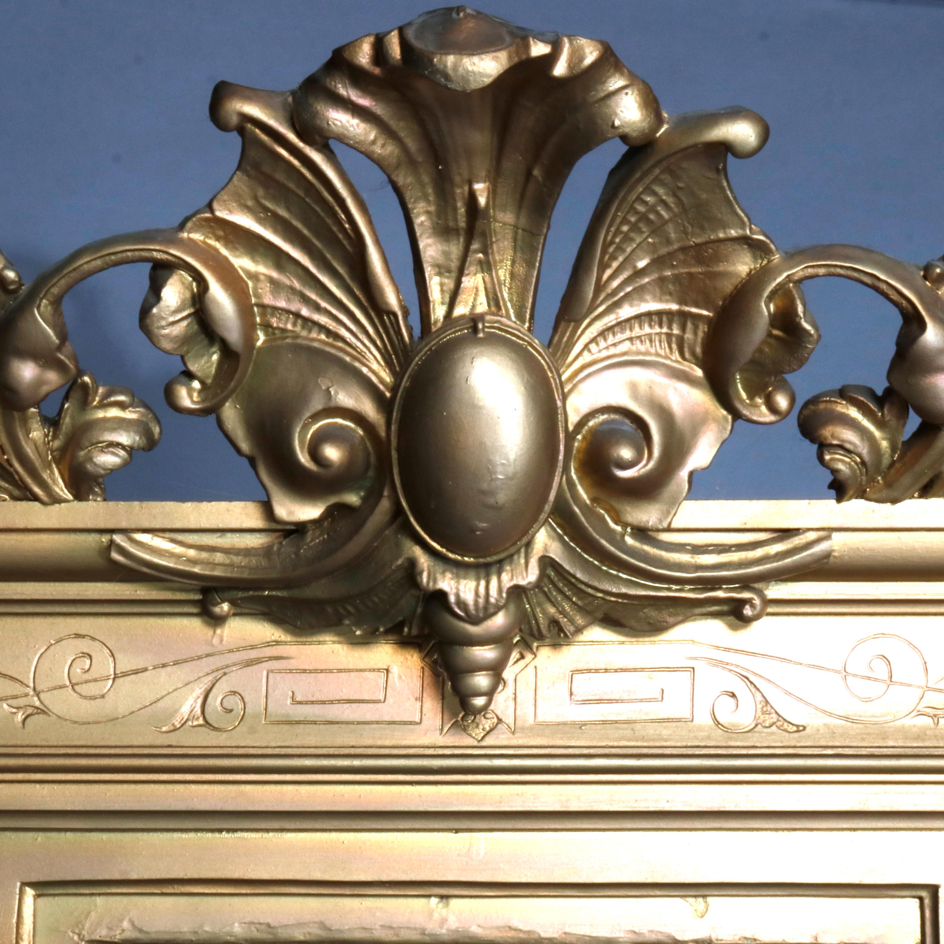 An antique French pier mirror offers giltwood construction with pierced fleur-de-lis crest surmounting incised scroll and foliate decorated frame, seated on shaped and beveled marble top base having stylized turnip feet, circa 19th