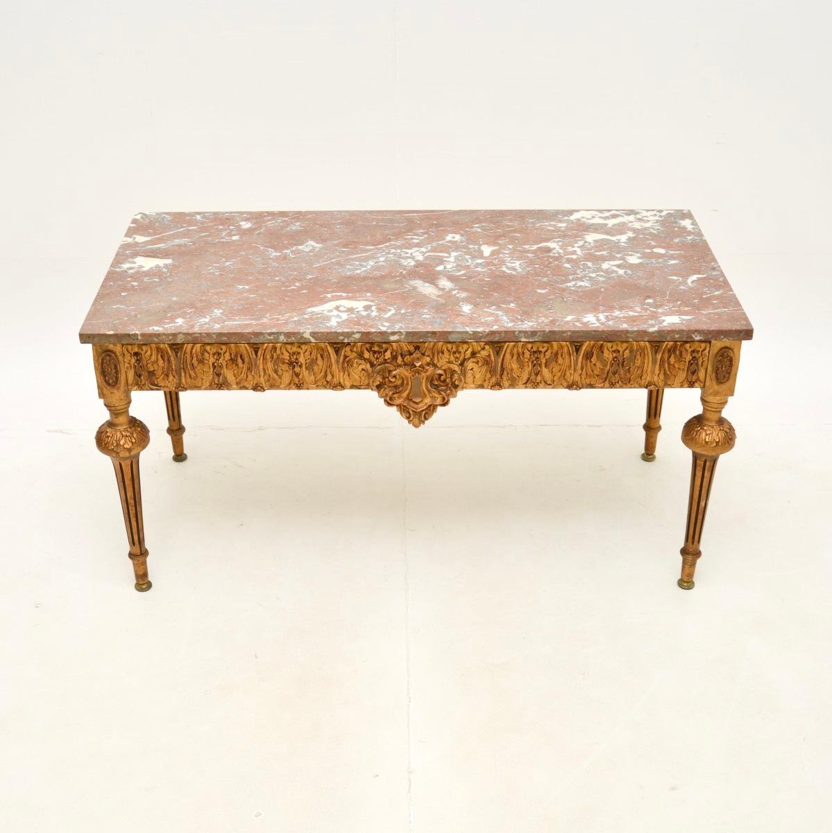 A beautiful antique French gilt wood marble top coffee table, dating from around the 1930’s.

This has a stunning design, the gilt frame is made from solid wood with ornate gesso mouldings. The marble top has gorgeous colour tones and patterns, it