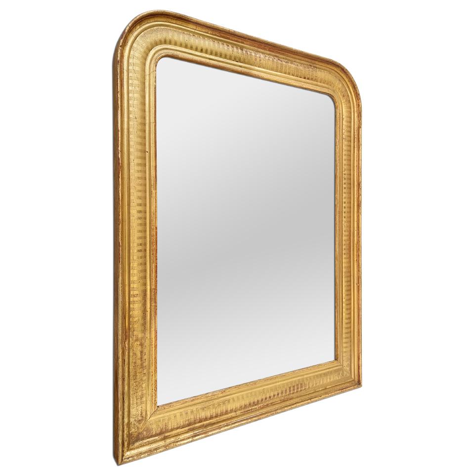Antique French mirror of Louis-Philippe style, in gilded wood with patinated gold leaf. Adorned with stripes engraved. Mirror frame made by the French company 