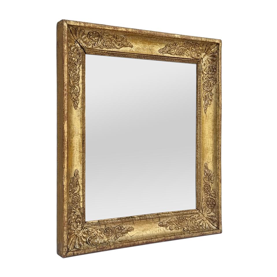 Antique French Restoration period mirror in gilded and stuccoed wood. Decorated with palmettes in the corners and rais-de-coeur around the edge of the glass mirror. Re-gilding with leaf and patina. Antique frame width: 5.5 cm / 2.16 in. Modern glass