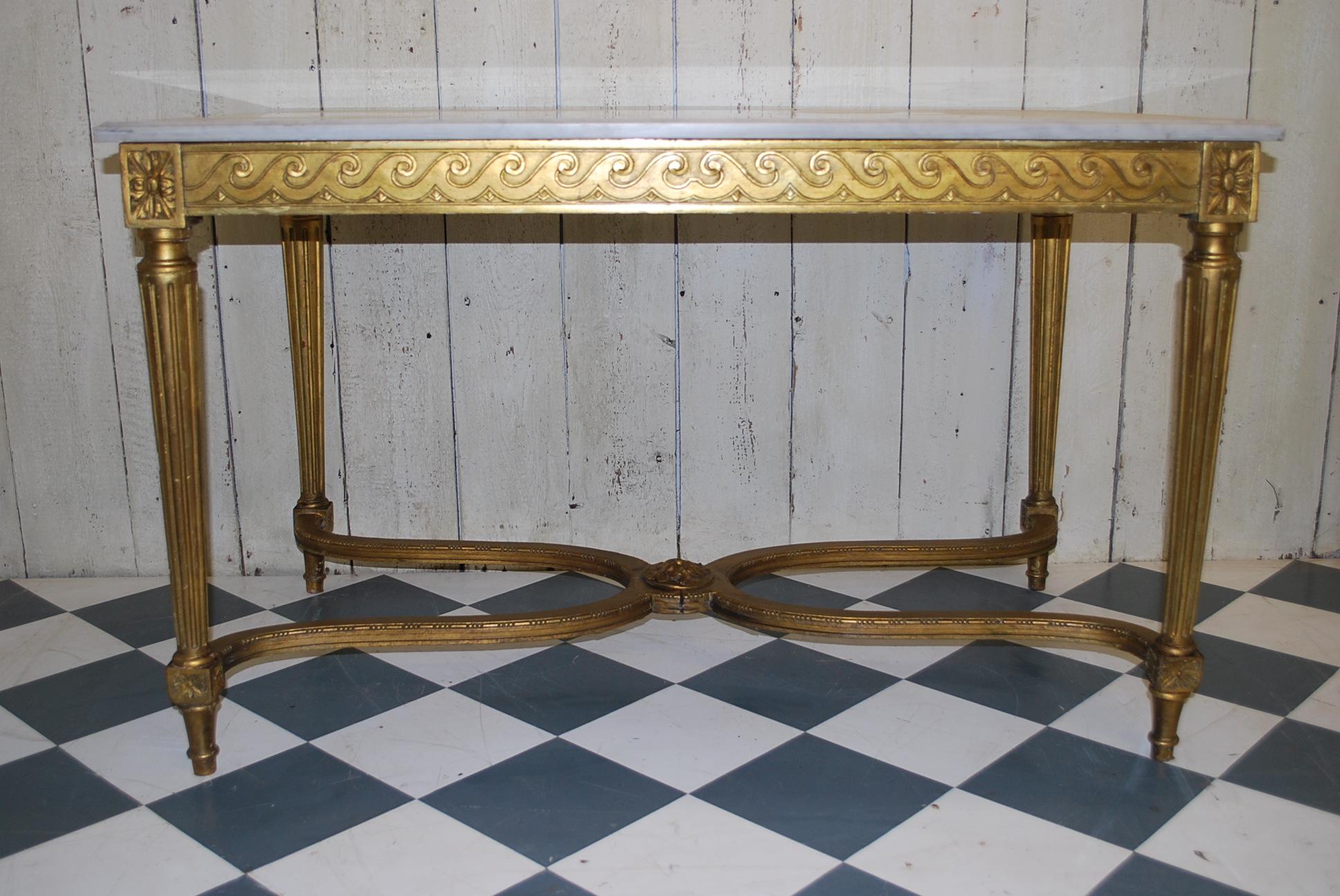 Carved giltwood French Napoleon III centre table, with Carrara marble top. Embellished with a carved wave decoration that runs all the way around the frieze. The turned legs that taper down with fluting, are united by shaped stretchers with a carved