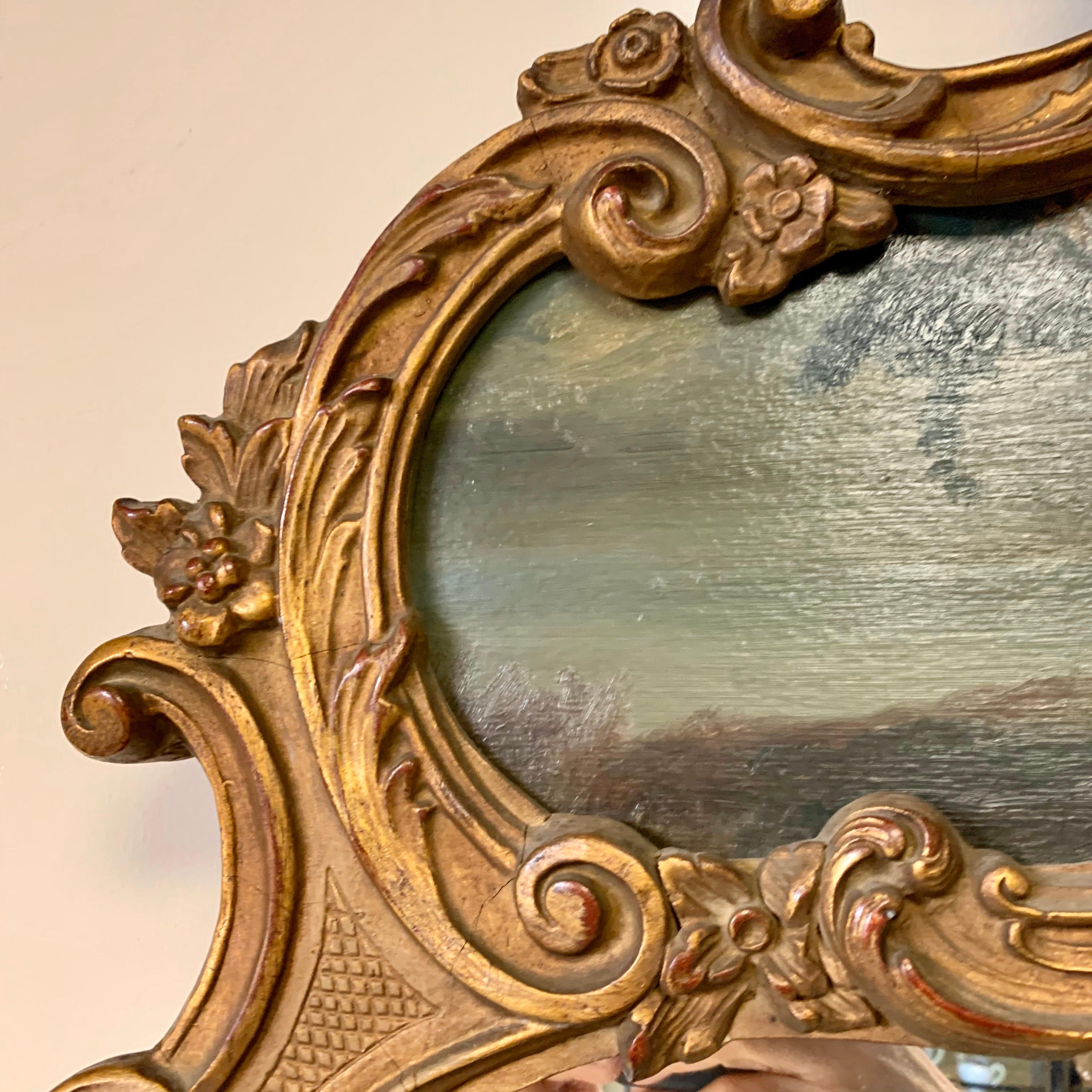 Late 19th century carved giltwood French Trumeau with the most exquisite signed oil painting at top. While most Trumeau's are rectangular in form, this one has quite a different shape, and it makes all the difference. The painting is signed by the