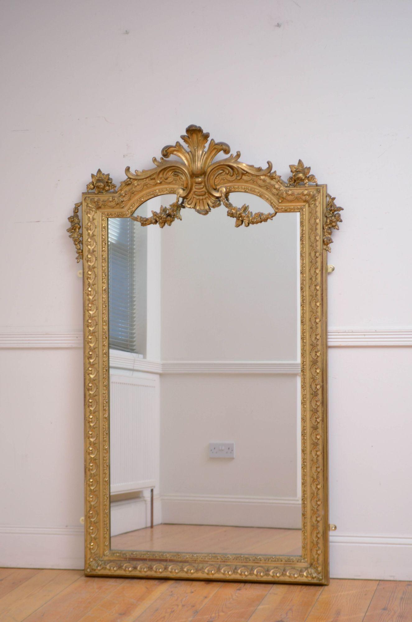 Sn5584 Attrayant miroir mural doré français du 19e siècle, avec plaque de verre arquée d'origine présentant de légères imperfections dans un cadre mouluré, doré et cannelé avec des volutes décoratives sur l'ensemble et un écusson en plumes de prince
