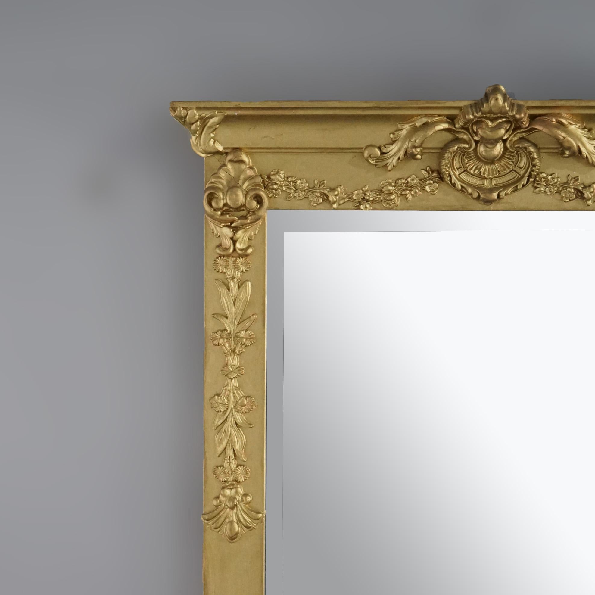 An antique French wall mirror offers giltwood frame with foliate elements throughout and housing beveled mirror plate, c1900

Measures- Overall 47.25''H x 25''W x 3.5''D; sight 19'' x 41''