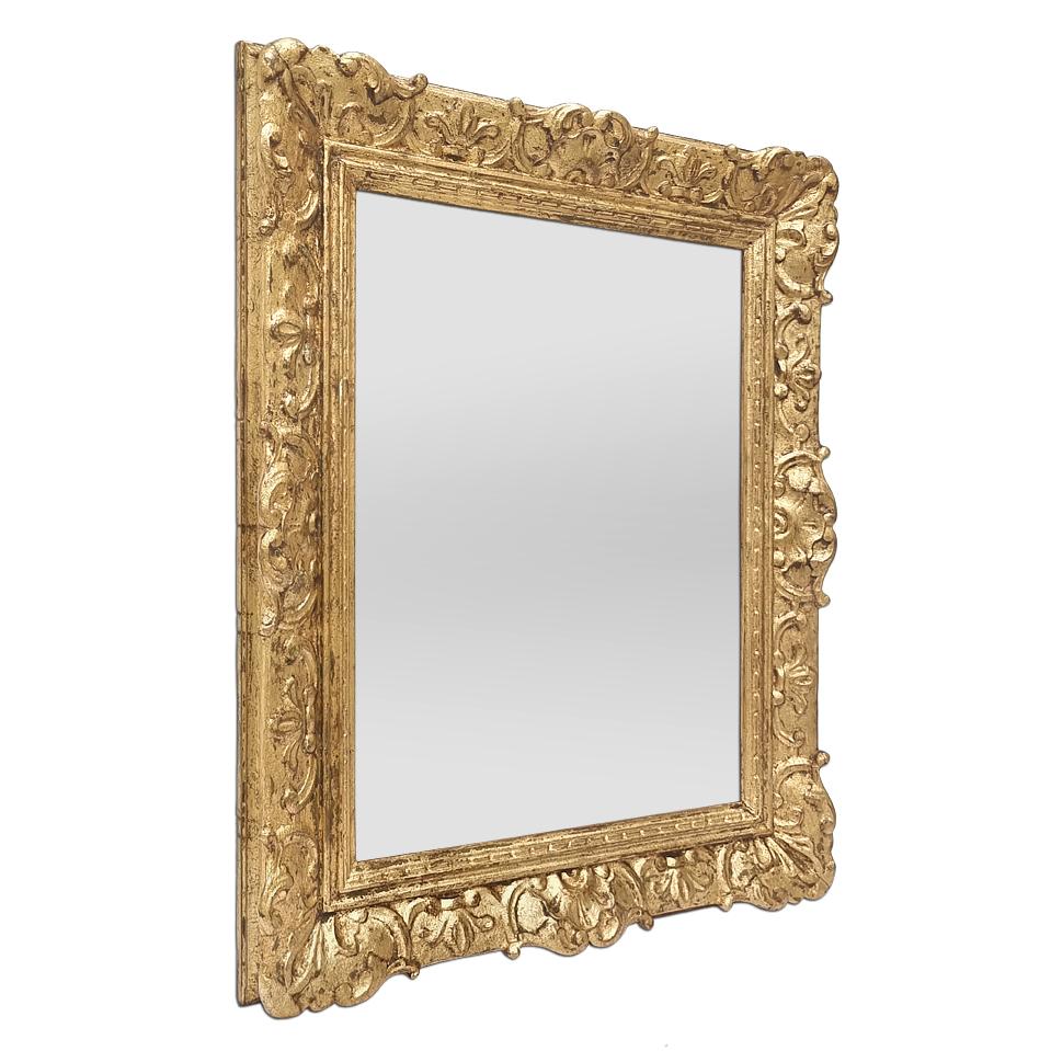 Antique French Louis XIV style giltwood wall mirror, circa 1940. Gilded carved wood frame, decorated with stylized shells, re-gilding patinated with leaf. Frame width: 6.5 cm / 2.55 in. Modern glass mirror. Wood back.