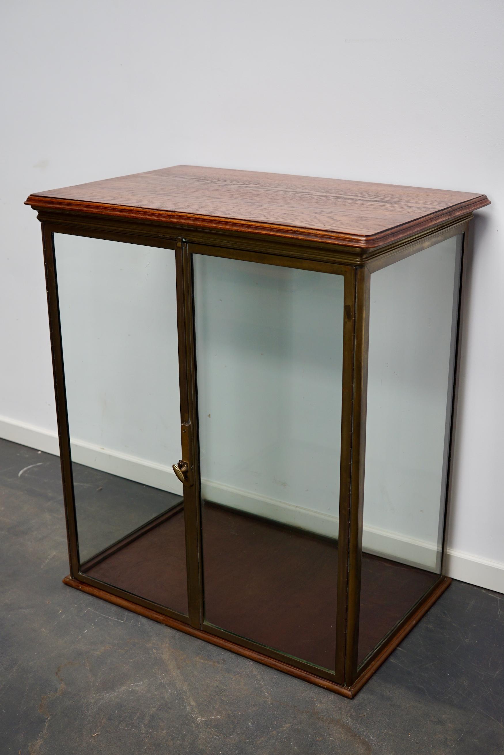 This very nice brass and glass vitrine was designed and made around the 1920s in France. It was made from brass and finished with an oak top. The build quality of the item is very solid.