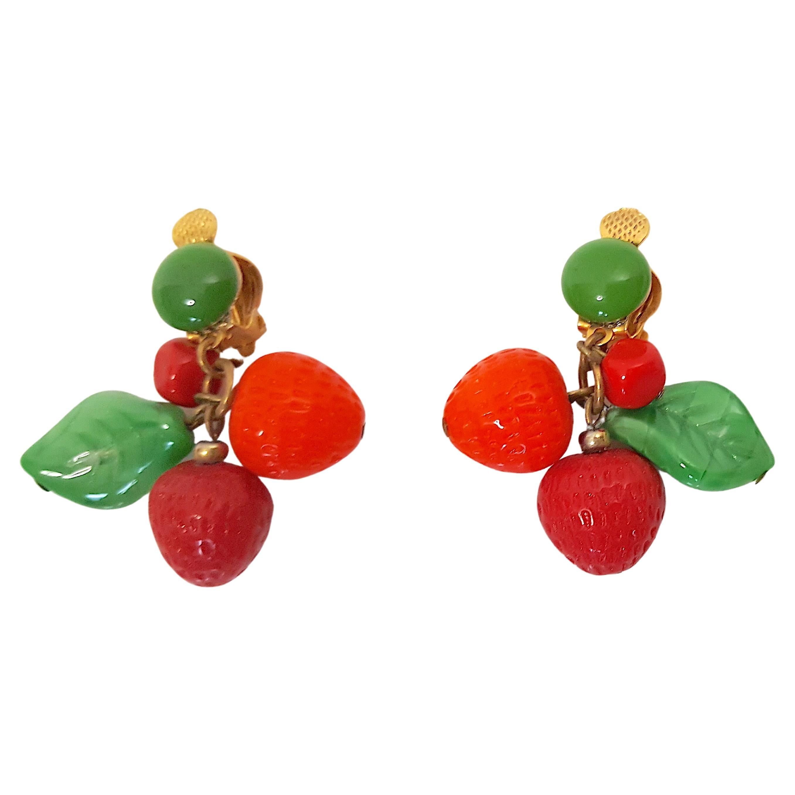 These antique early-20th-Century French carved lampwork glass bead earrings depict berries and leaves. On each earring, this fruit salad dangles on a single ring that drops from a round convex green 