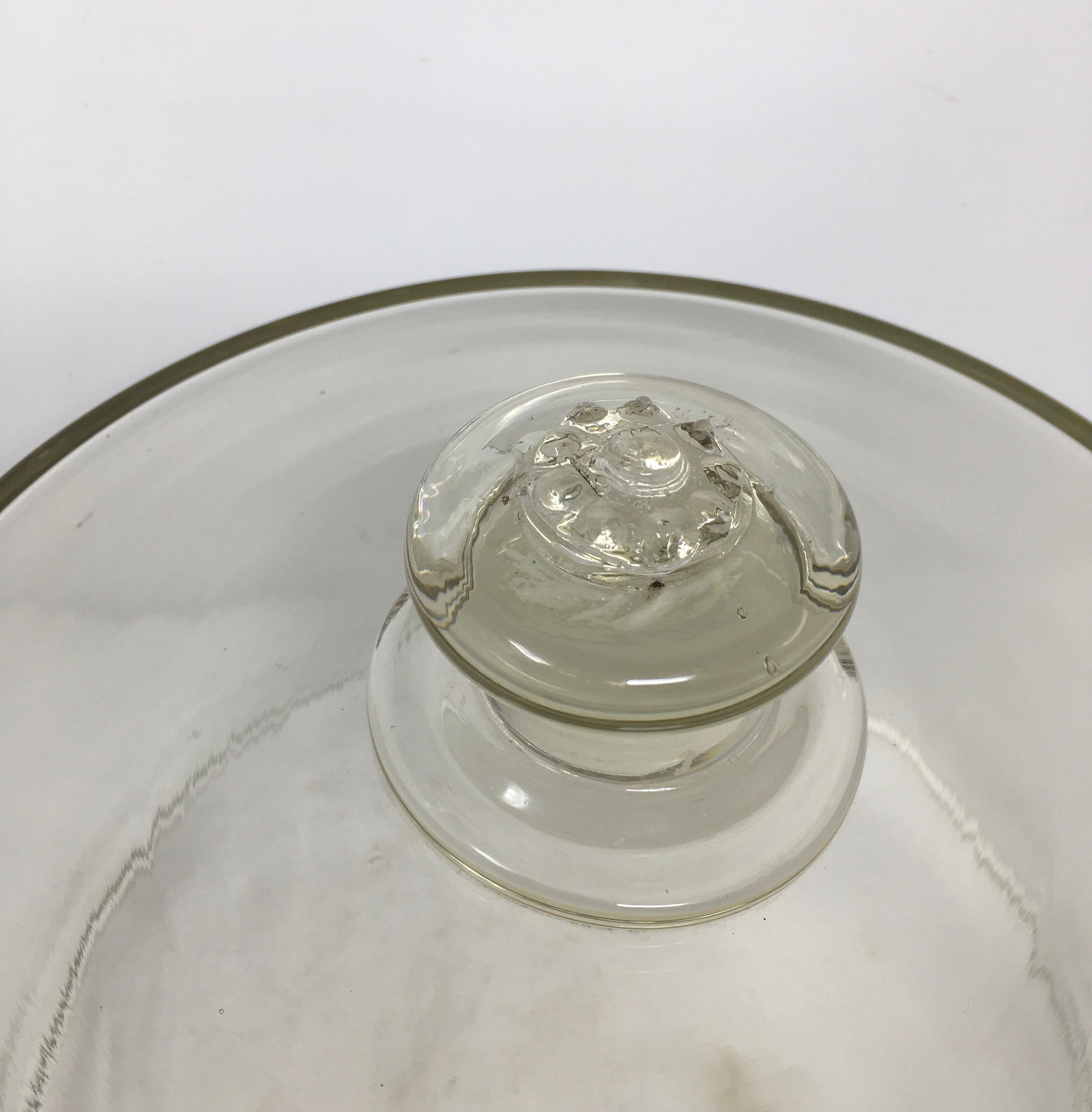 Found in France, this glass cheese or pastry cloche is topped with a solid glass handle/knob. This charming dome has many bubbles and irregularities. Very decorative, could be used to cover food or plants.