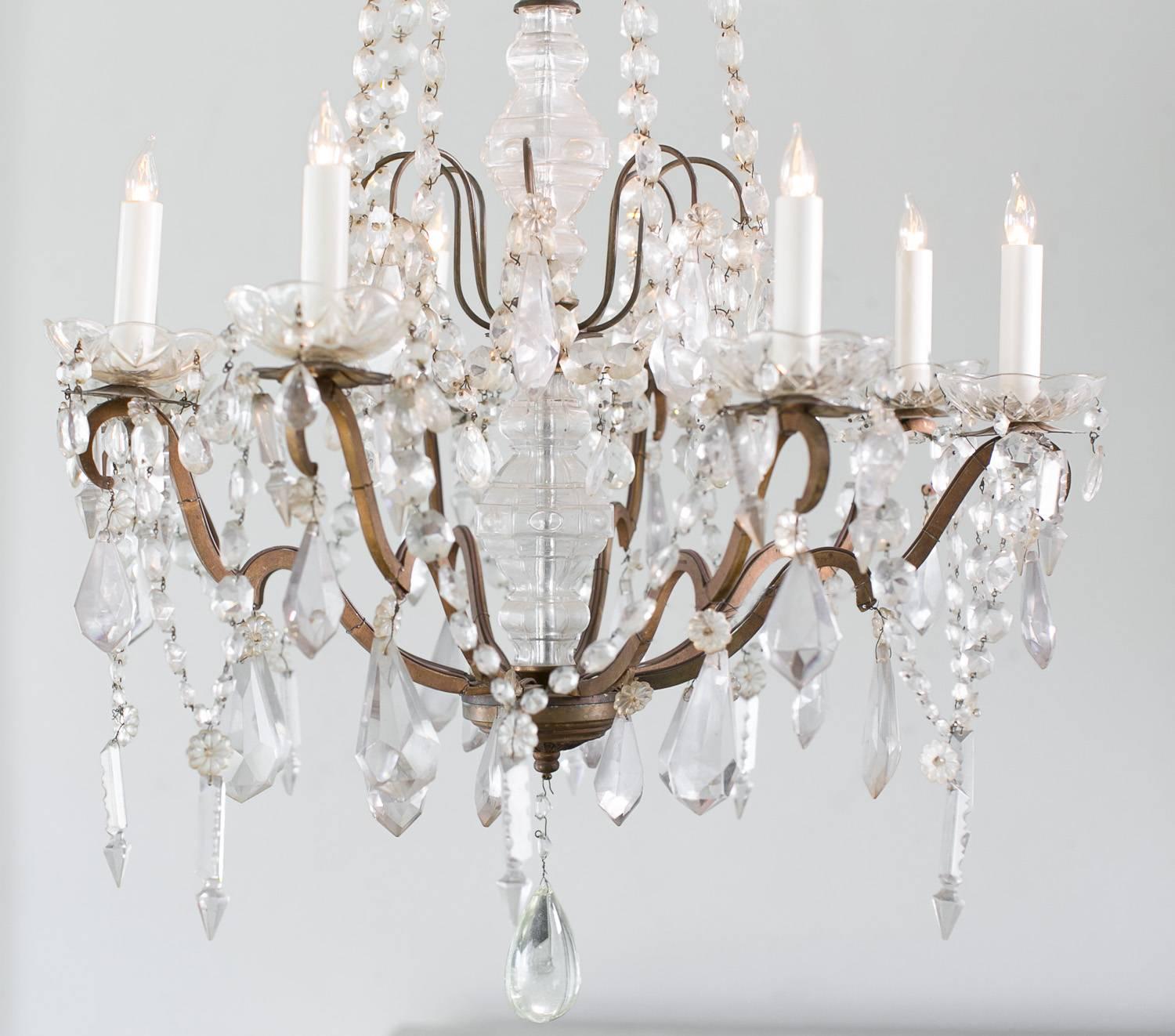 Gorgeous chandelier with heavy crystals, elegantly draped beads cascade downward from the center and connect to the eight arms. Candles are cupped in etched crystal bowls and connected with darts. Center piece is covered in glass. Metal is