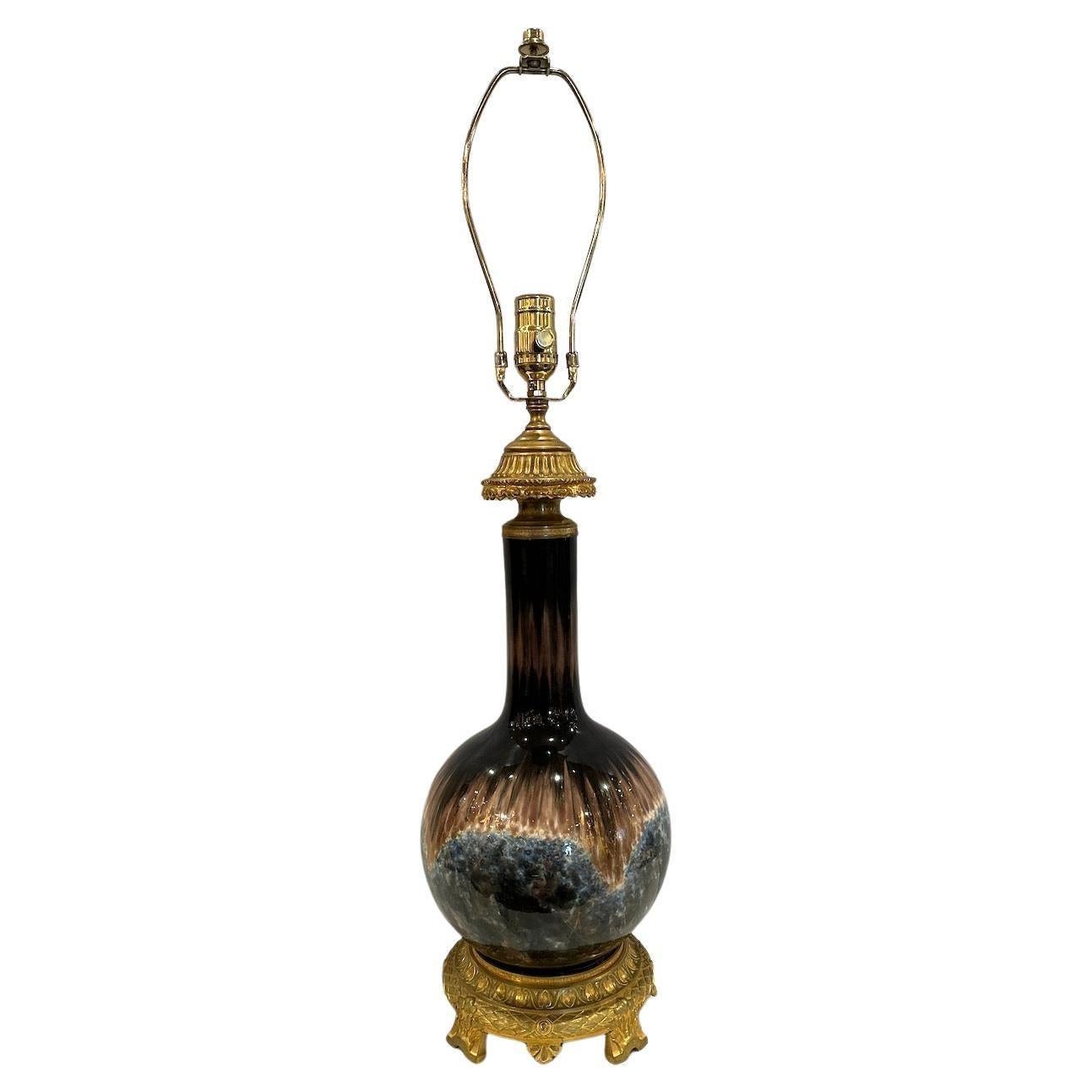 Lampe de table à gaz richement peinte, émaillée et parcellairement dorée, convertie à l'électricité, avec des montures dorées.   Abat-jour tissé blanc cassé de 18
