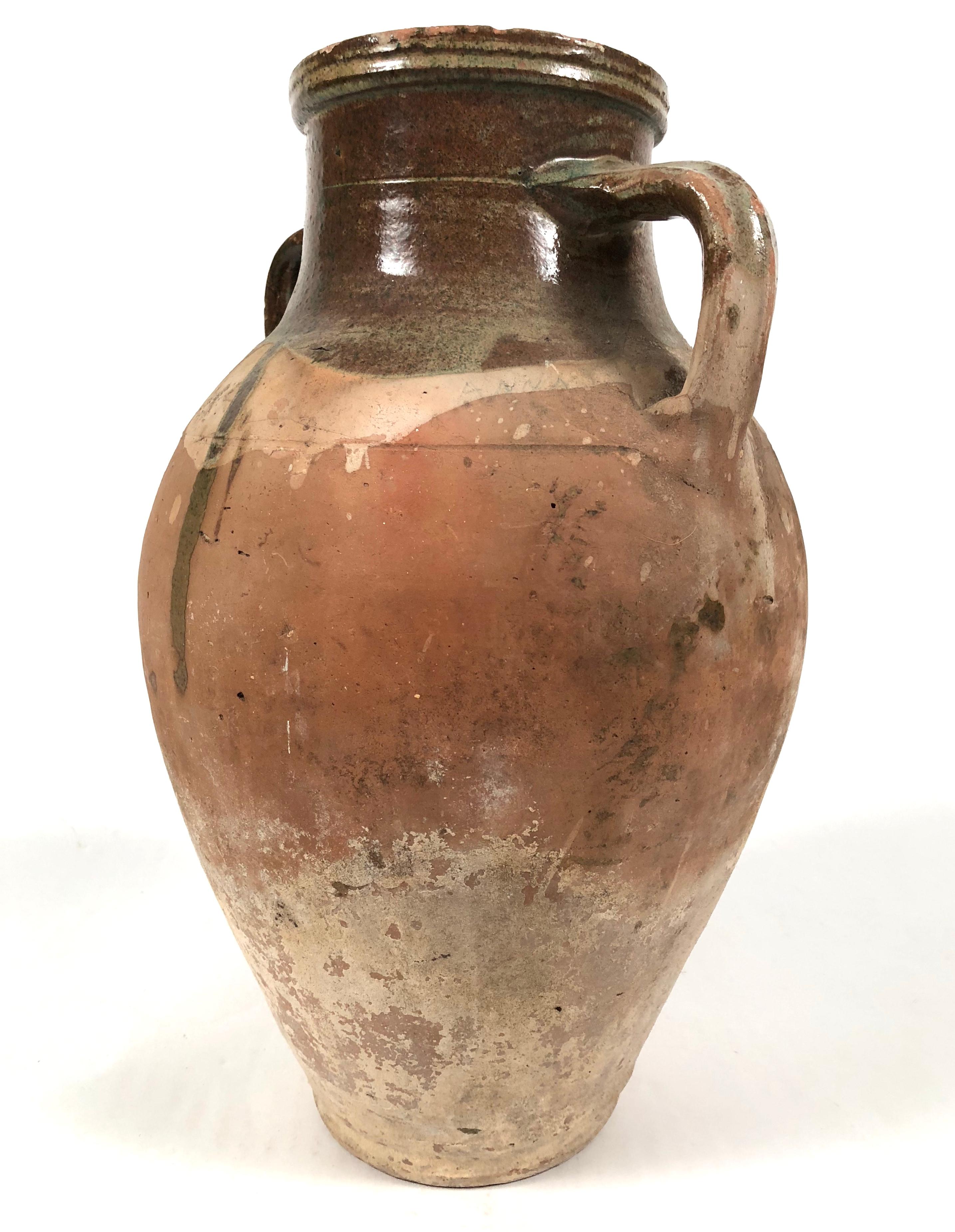 An antique French terra cotta confit pot, or Amphora, with sage green glazed drip decoration, of good size and with great character and patina.