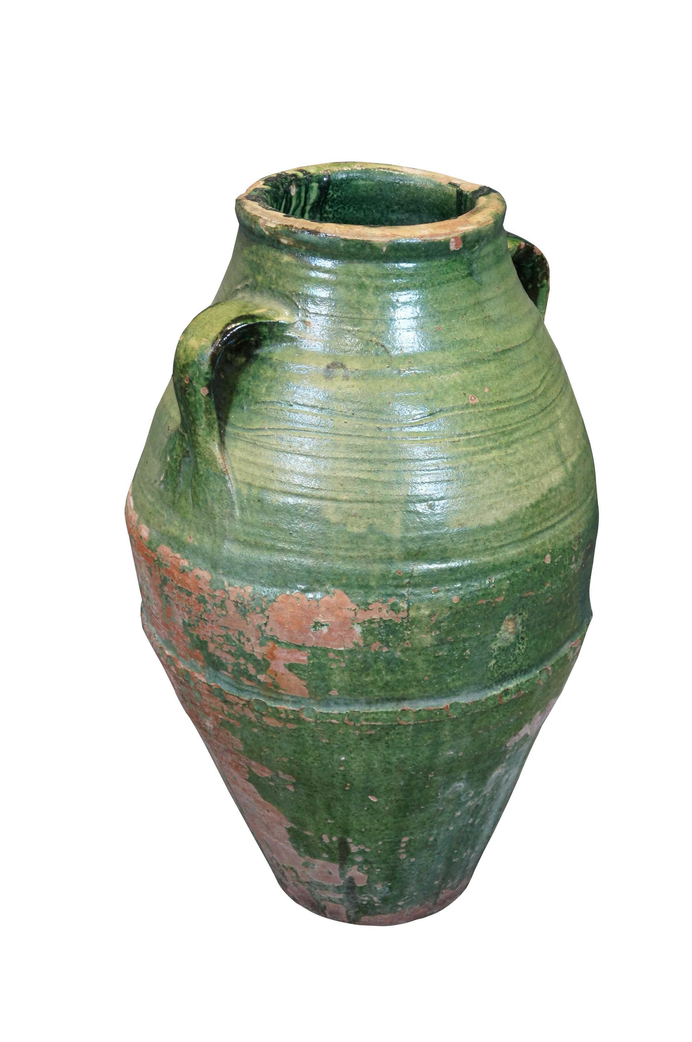 Ancienne jarre à olives / vase de sol en terre cuite - forme en amande avec un large milieu et un sommet / base effilé, deux poignées, bande décorative tachetée / empreinte de pouce autour du milieu, finie dans une glaçure verte.

Dimensions :
15
