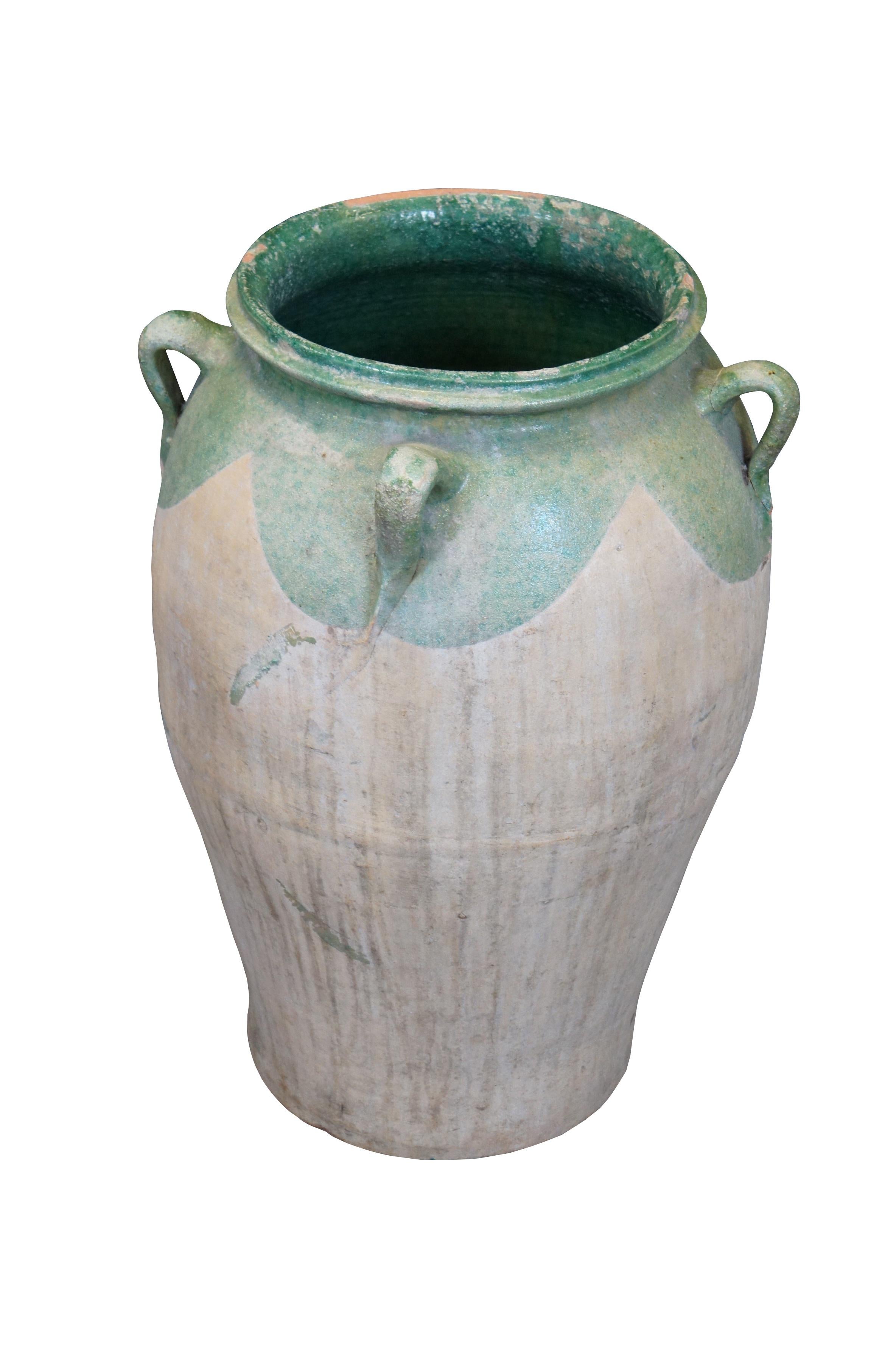 Amphora / vase de sol français ancien, fabriqué à la main en terre cuite de couleur claire, de forme arrondie avec une base effilée, un bord / intérieur émaillé vert moulé, et quatre anses.

Dimensions :
17