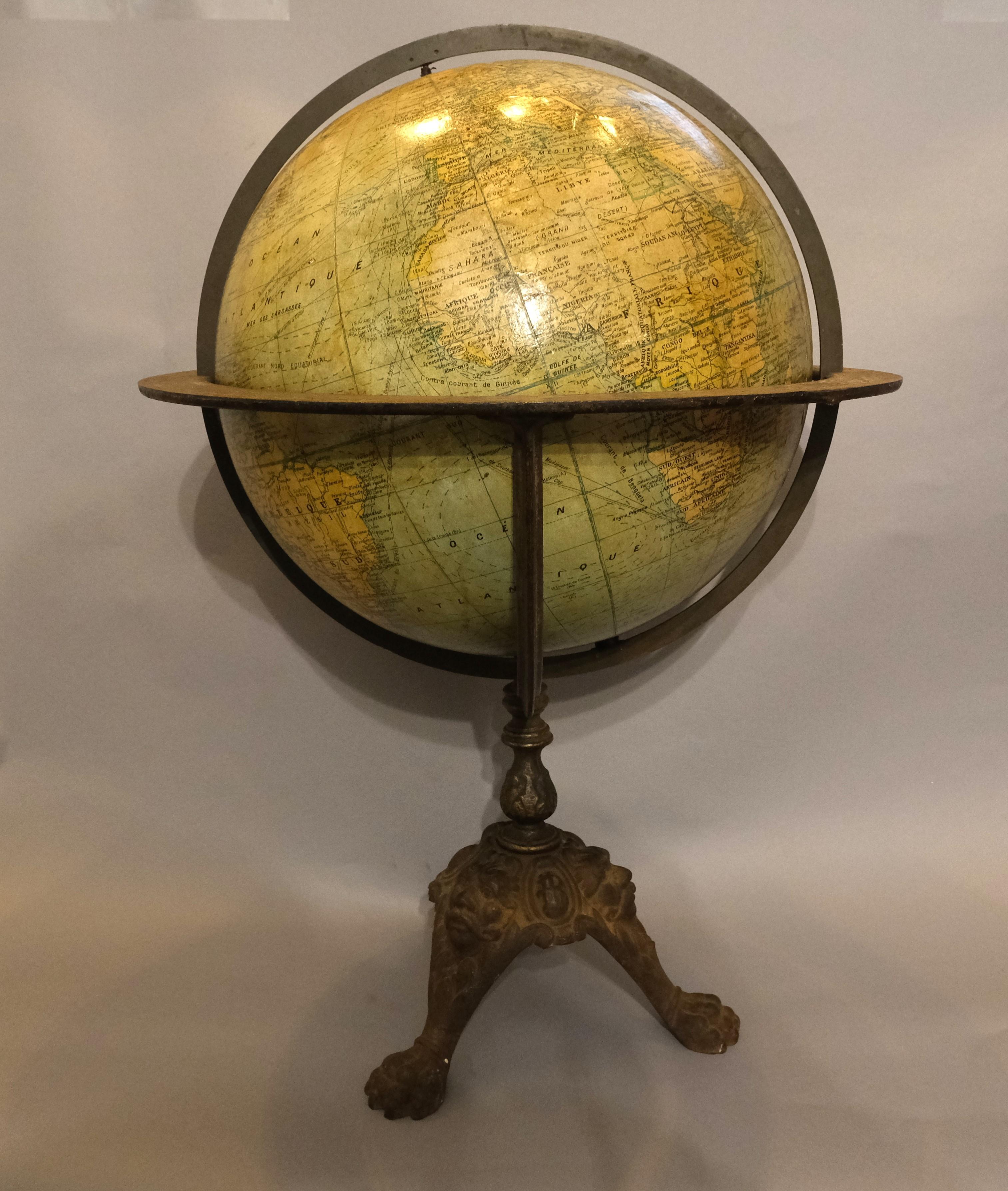Hutton-Clarke Antiques is delighted to present a French globe dating back to circa 1900. This piece boasts a considerable size and stands on an elegant cast iron base, featuring paw feet and ornate heads on the cabriole legs. It is in fairly good