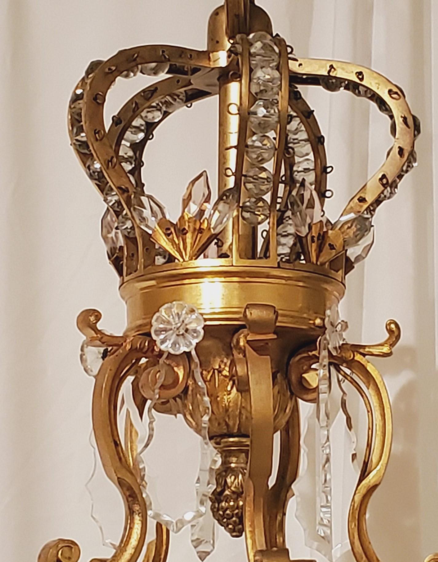 This chandelier has a charming crown atop.