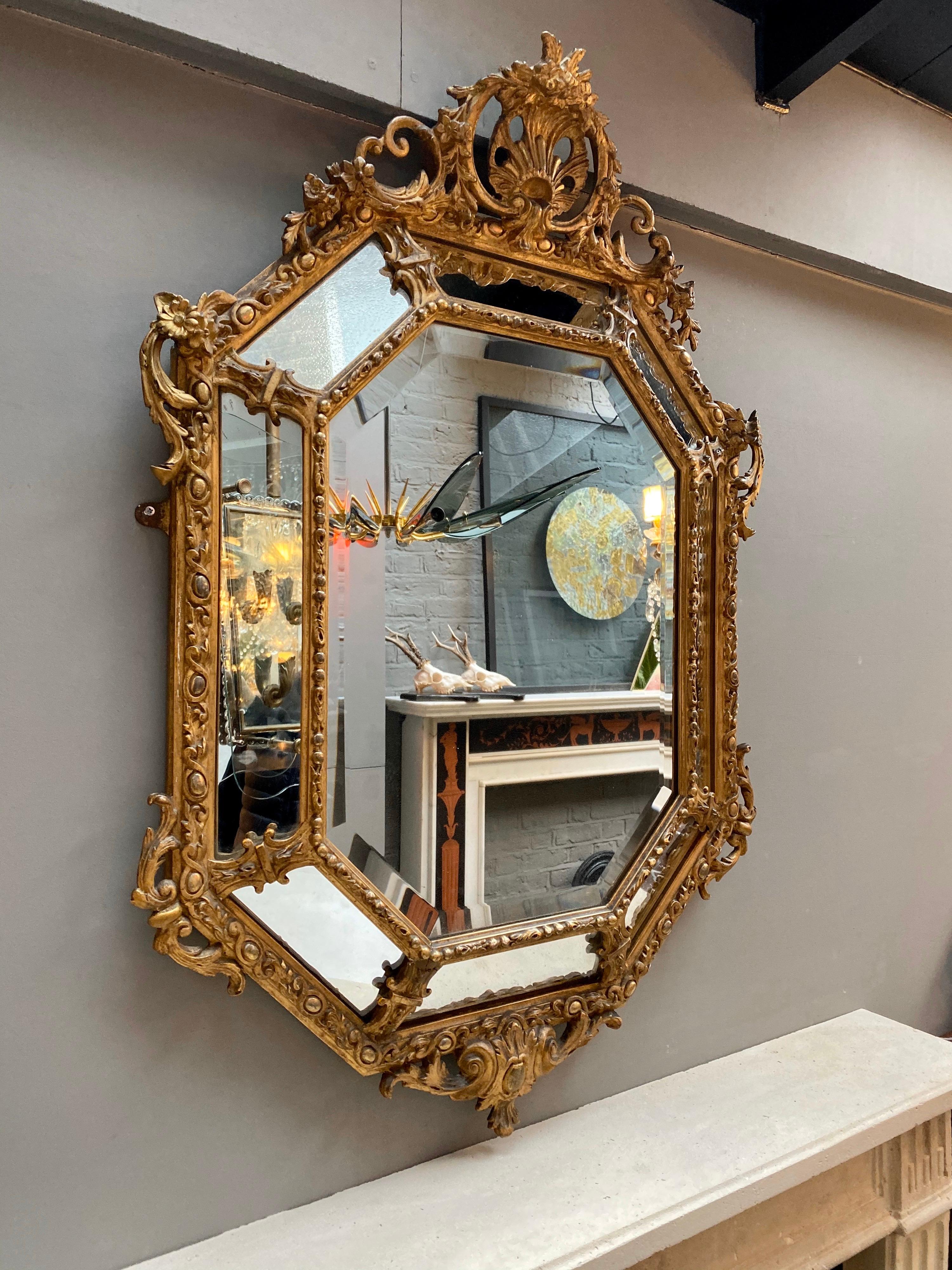 A well proportioned French cushion mirror from the mid-late 19th century, retaining its original mirror plate. The pediment of scrolled foliage, flowers and shell cartouche, with conforming outer border decorated with flowers and foliage, inner