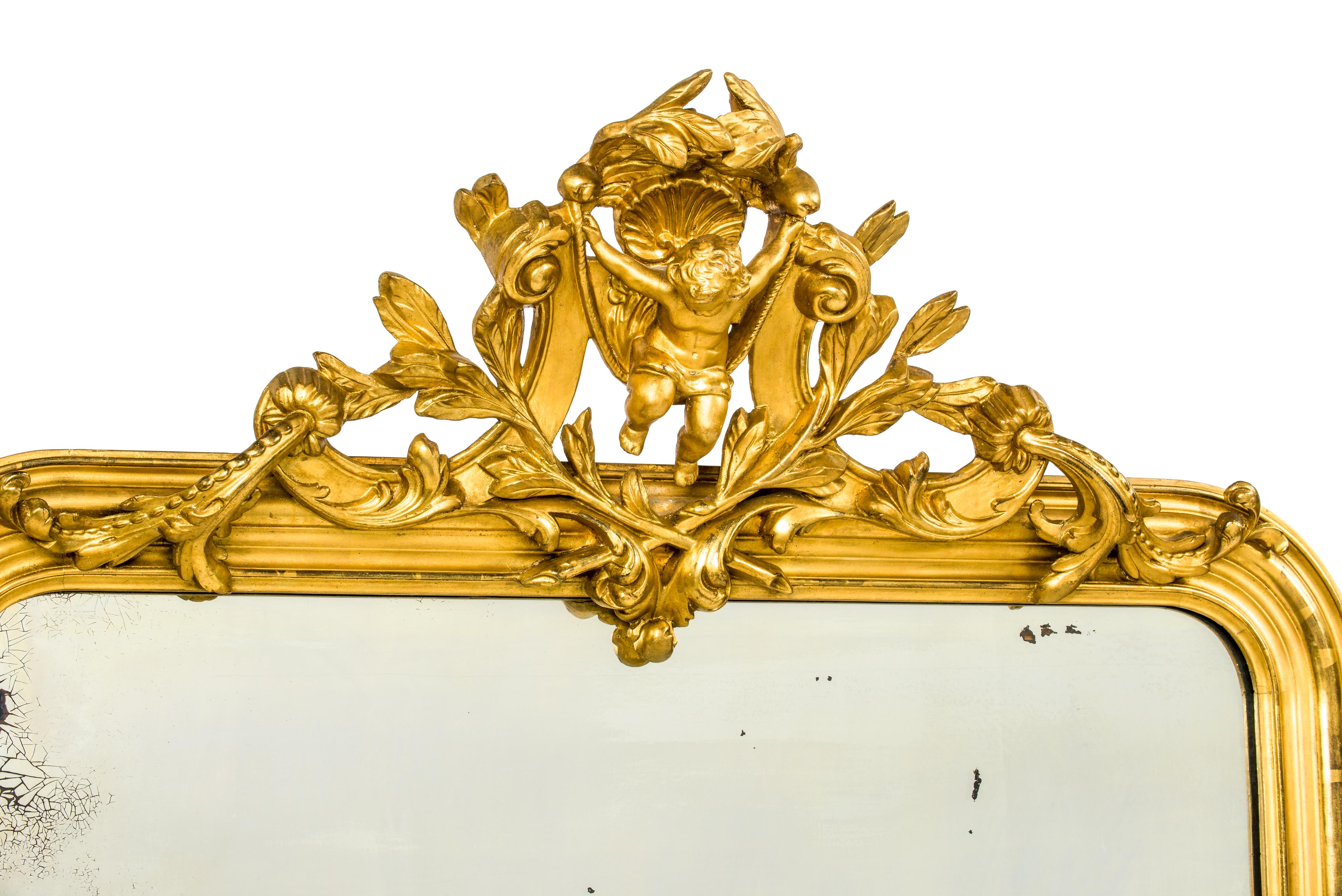 This beautiful golden mirror was made in Northern France in 1879 as is carved in the crest.
The mirror was enriched with an elaborate crest featuring central putti or angel figure swinging on a rope. The putti are flanked by scrolls, acanthus, and