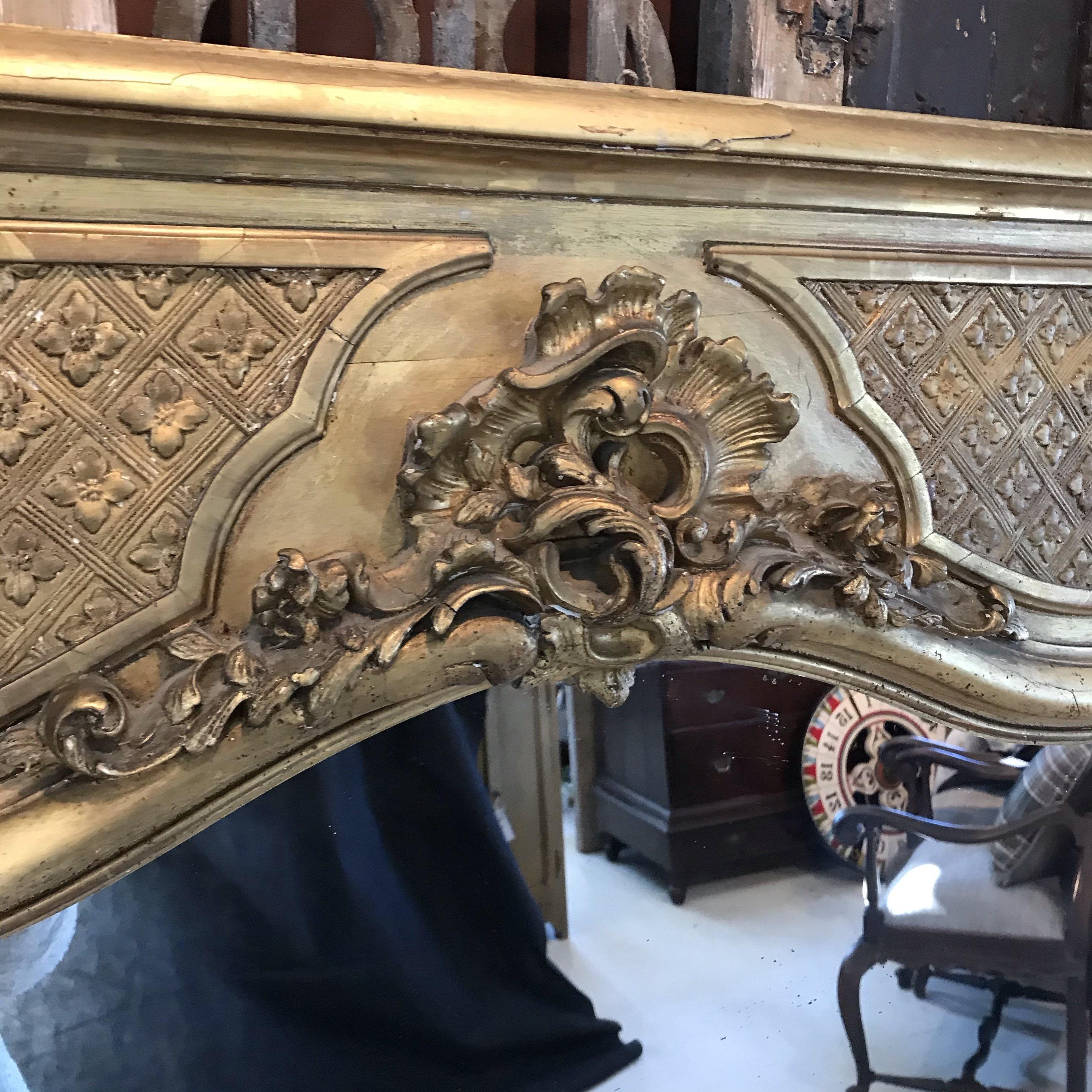 Beautiful antique rectangular Louis Philippe mirror is completely gold leaf gilt adorned with wonderful ornaments. The sculpted cartouche at the top is centered upon a large diamond patterned inset top. Mirror is in very good antique authentic
