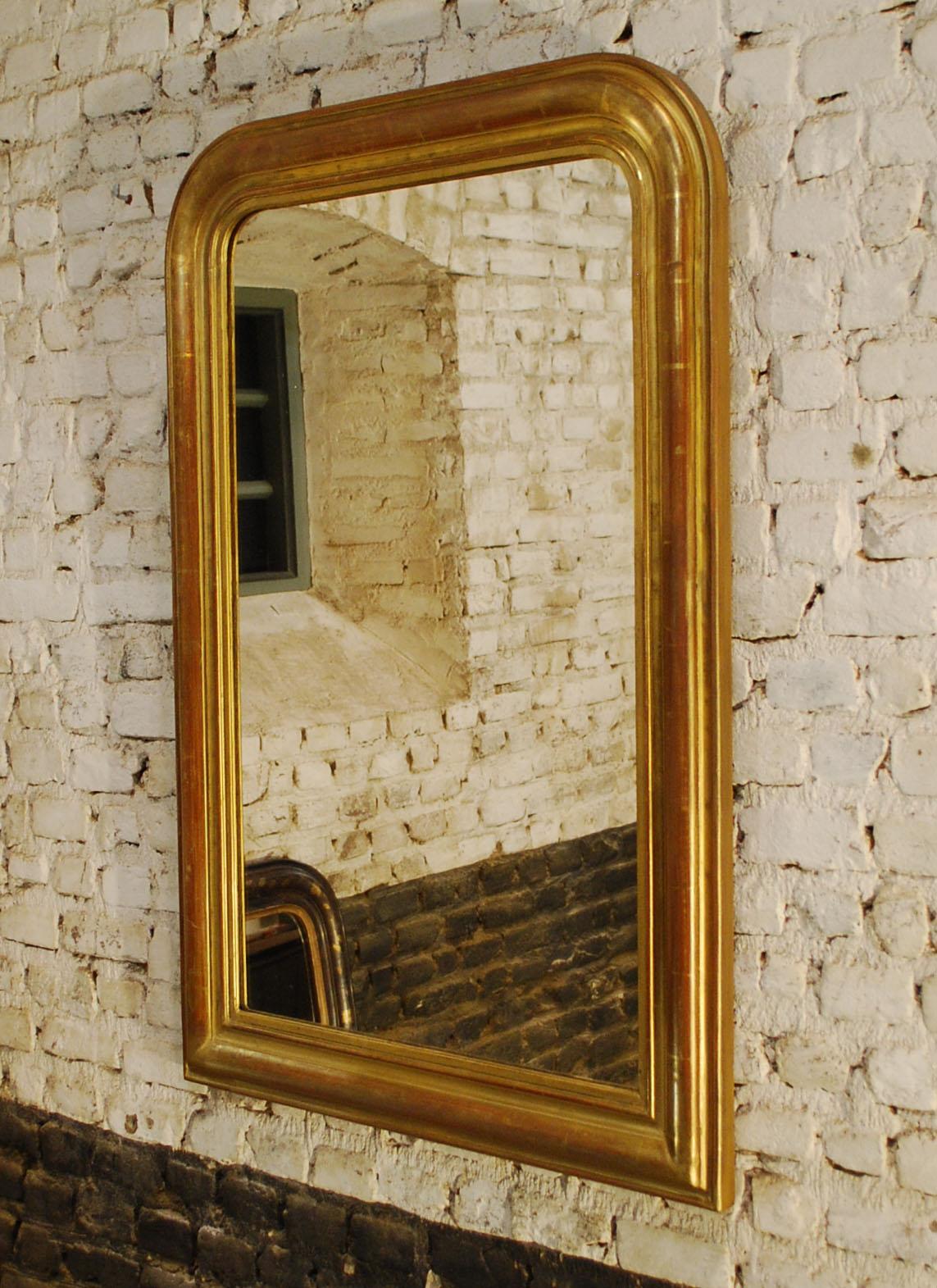 This simple yet elegant mirror was made in France, circa 1880.
It has the upper rounded corners typical for Louis Philippe mirrors. The sleek frame is partially gold gilded and partially gold painted. This was a general practice and provided a way