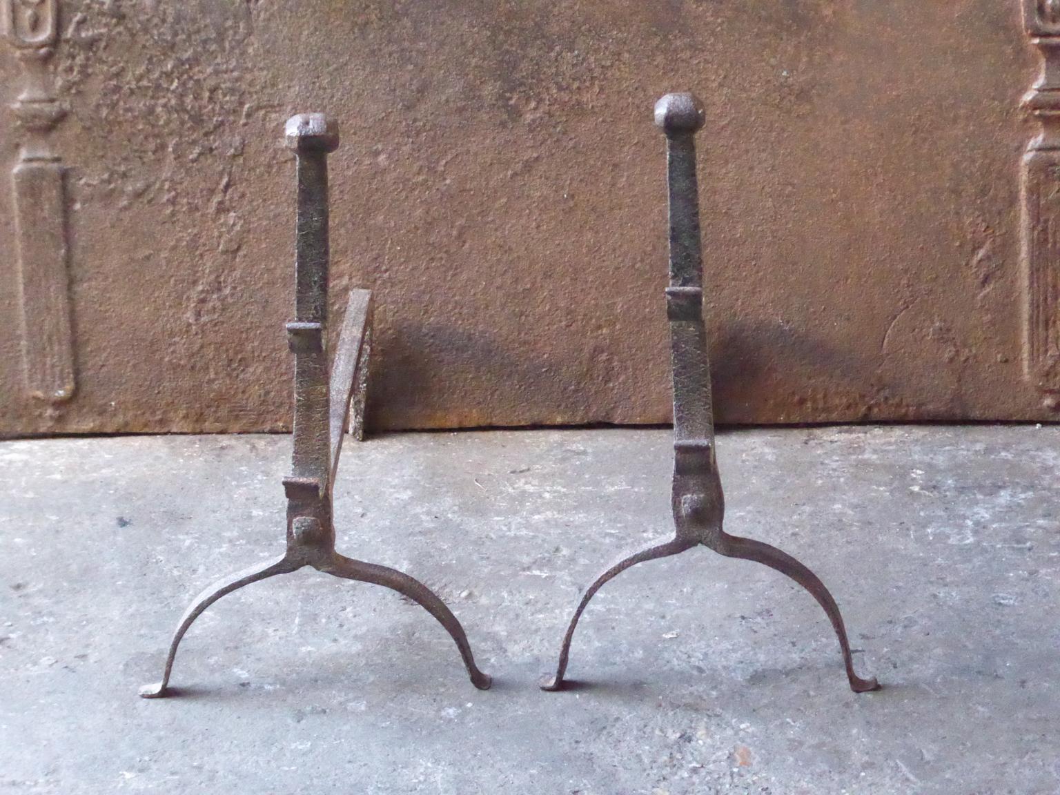 17th century French andirons made of wrought iron. The style of the andirons is gothic. The andirons have spit hooks to grill food. They are in a good condition.
