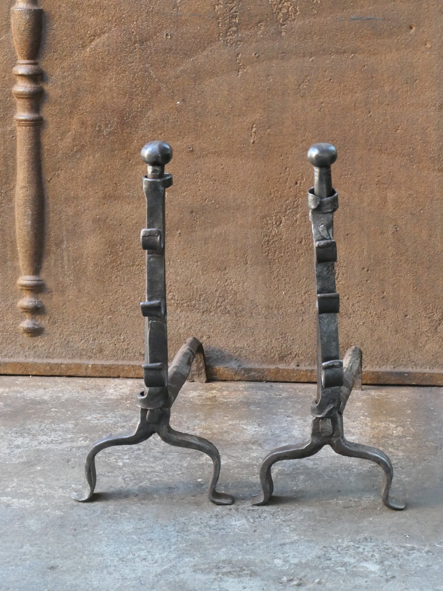 17th century French andirons made of wrought iron. The style of the andirons is gothic. The andirons have spit hooks to grill food. They are in a good condition.