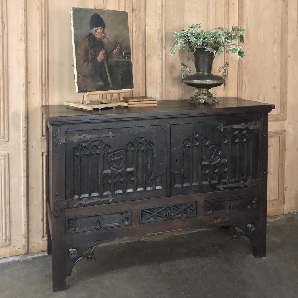 Antique French Gothic buffet boasts carved detail across the facade and even on the supports underneath, enhanced by the bold steel strap hinges and lockwork for a wonderful masculine appeal,
circa early 1900s
Measures: 40.5 H x 55 W x 20 D.