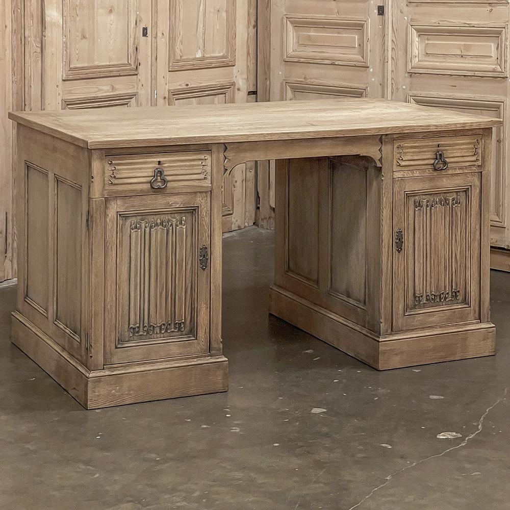 Antique French Gothic Executive Desk in Stripped Oak is finished on all four sides, and features timeless linenfold carvings on each of the cabinet panels, with horizontal linenfold panels positioned above.  The solid oak plank top will ensure