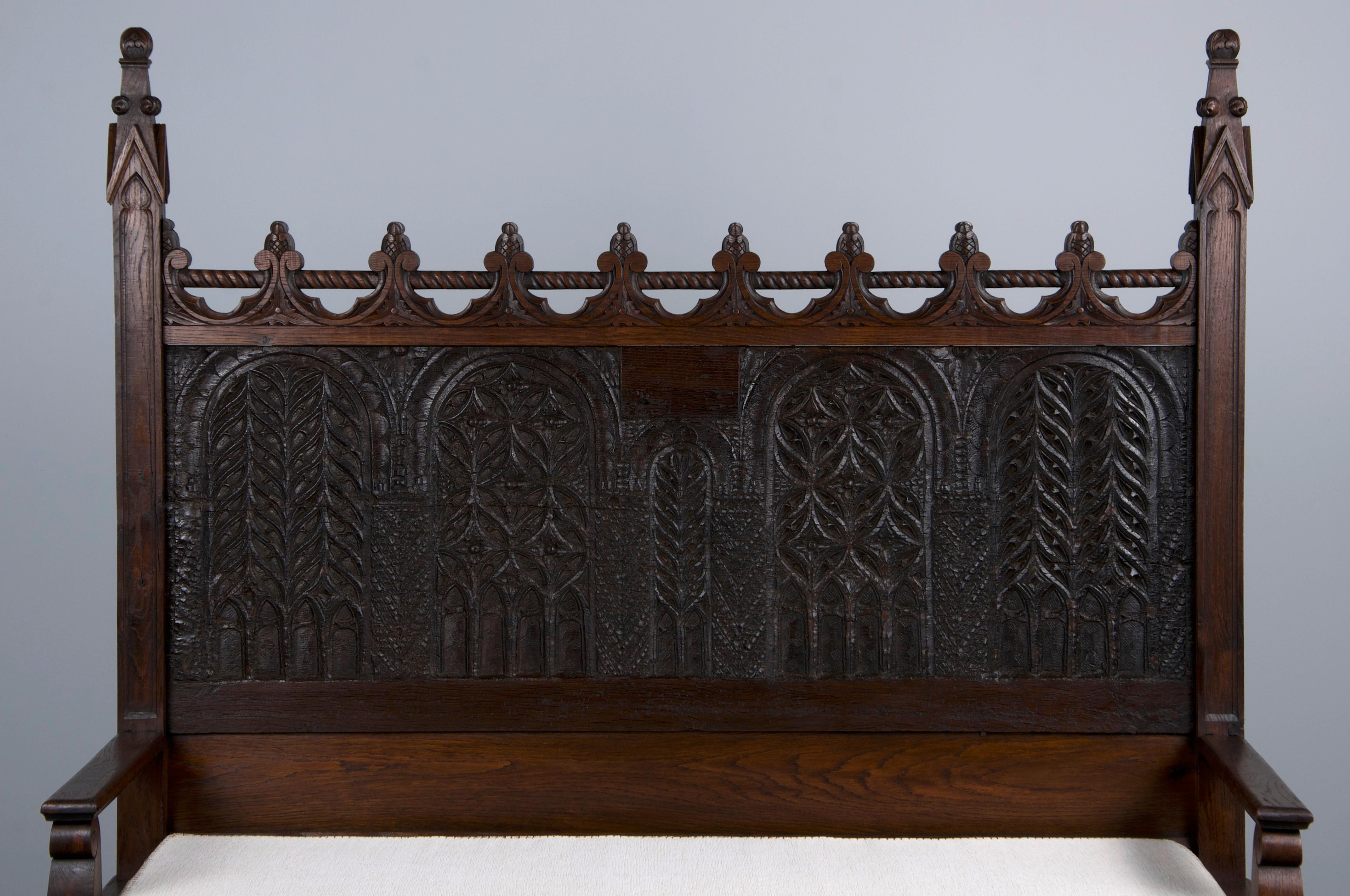 A magnificent late 19th-century French hallway storage bench or settee, sourced from Provence, France. Beautifully handcrafted from solid oak, it showcases a naturally aged dark patina with rich dark brown hues and visible wood grain. The back