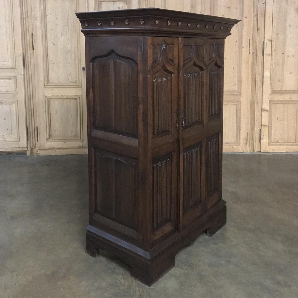 This handsome antique French Gothic solid walnut armoire, Bonnetiere was created from fine French walnut, and features an intriguing double door access with one corner door with bi-fold hinges, making it ideal for installing a surprisingly large TV