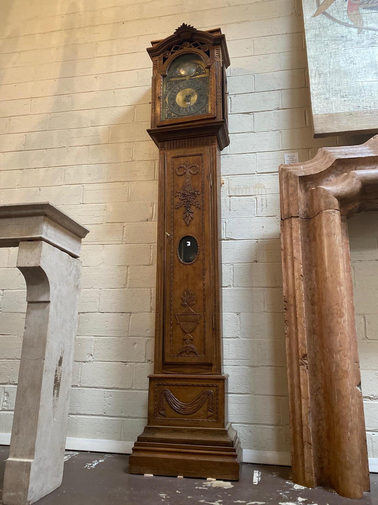 This grandfather clock originates from Belgium, circa 1850. It features a brass face with the words 