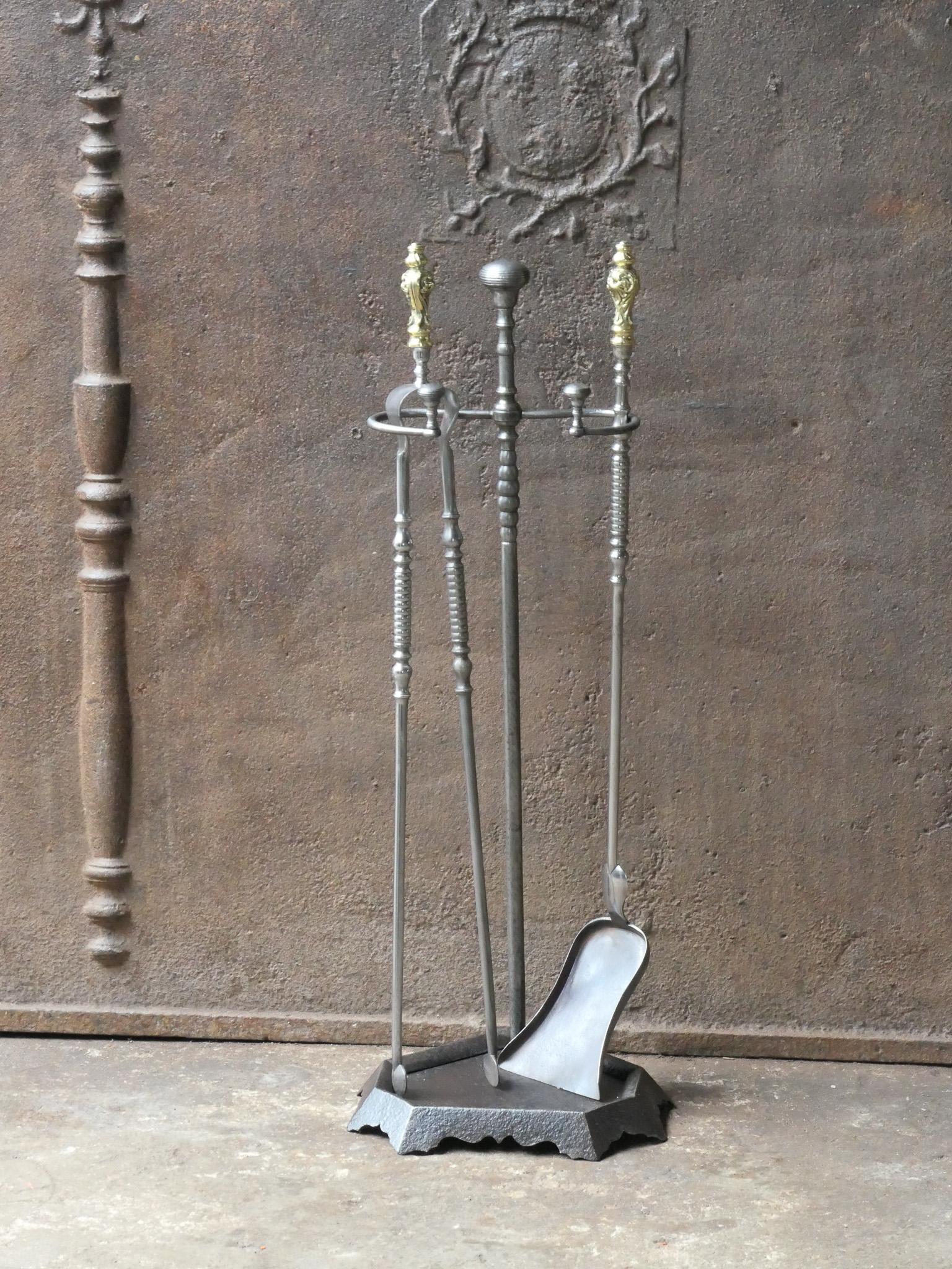 19th-century French Napoleon III period fireplace set. The tool set consists of thongs, a shovel and a stand. The tools are made of wrought iron with polished brass handles and the stand is made of cast iron. The set is signed by 'Grandy Fils'. The