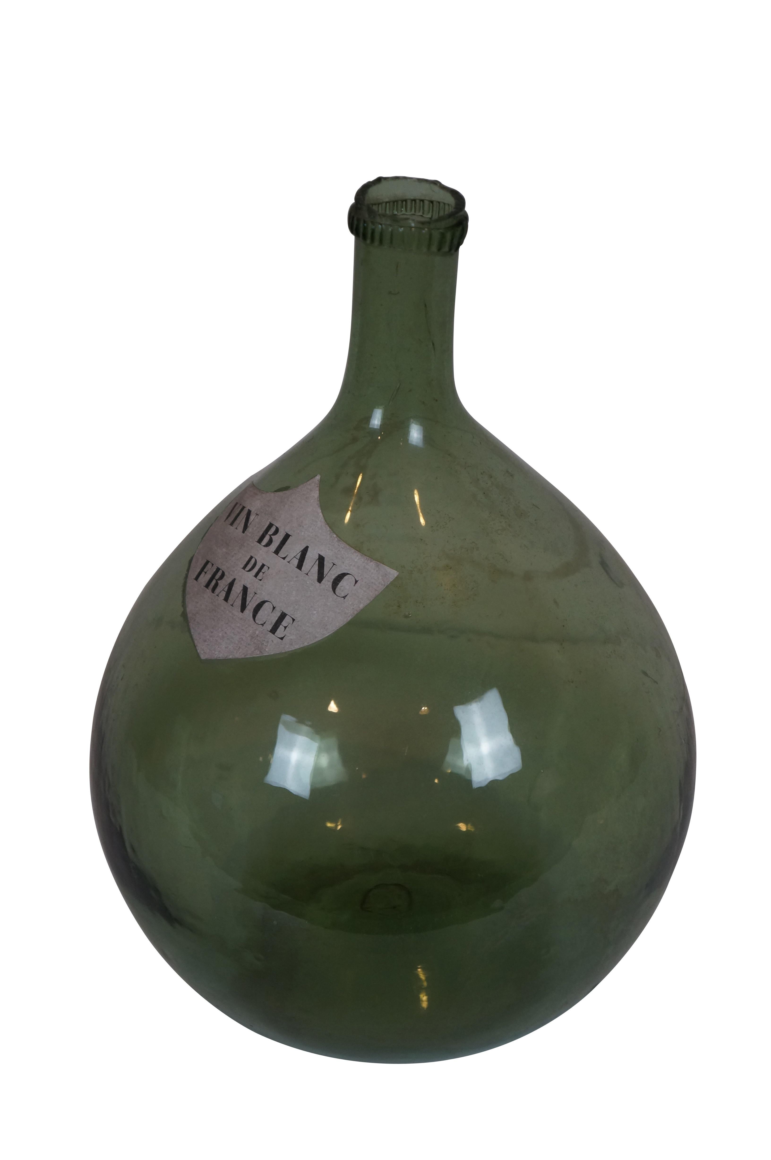 Early 20th century balloon shaped French demijohn / wine bottle / jug. Green glass with shield shaped paper label reading 