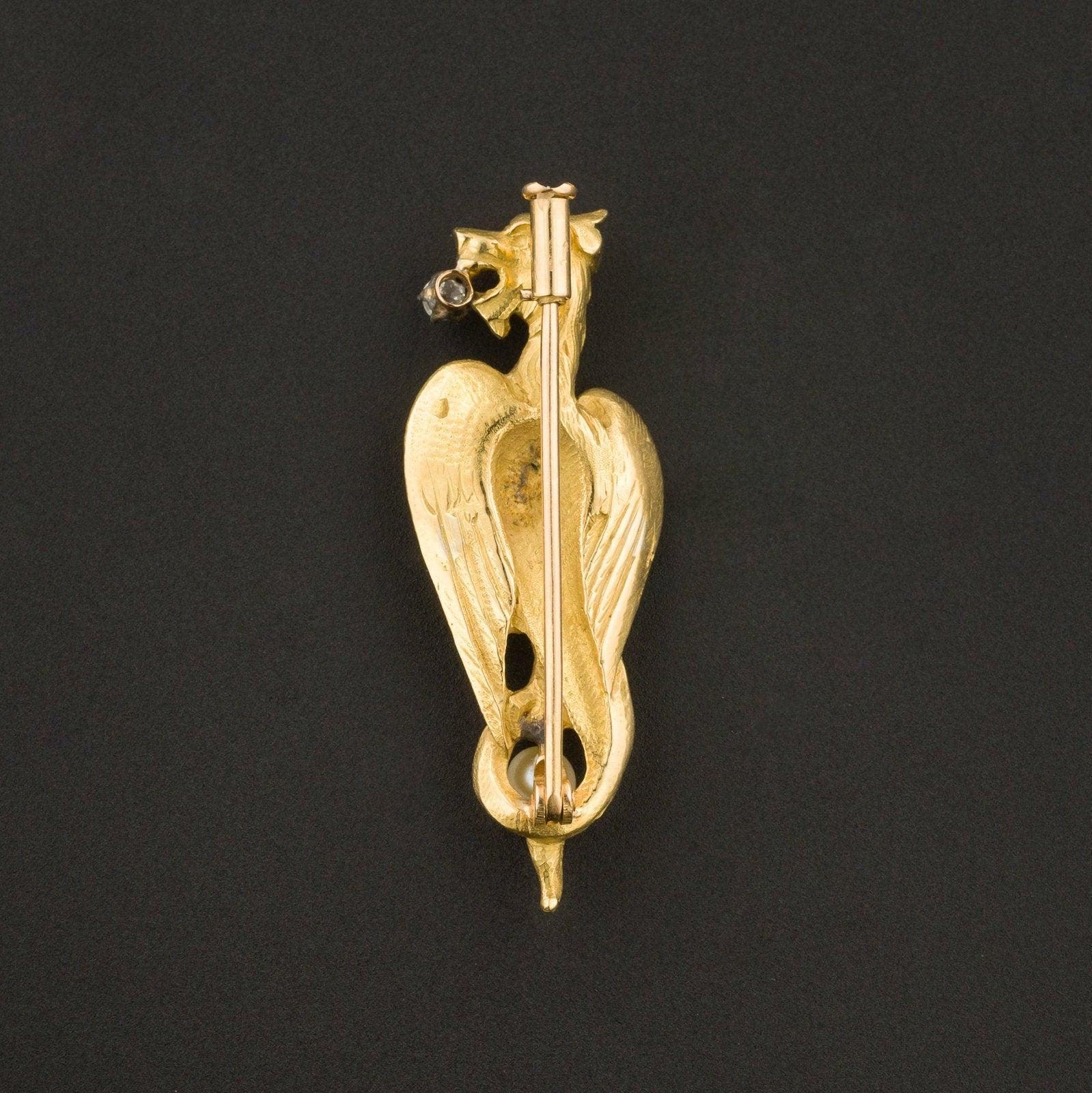 Diese exquisite goldene Greif-Brosche ist stark und symbolisch und verleiht Ihrer Garderobe einen Hauch von Faszination.

Die Brosche ist fein in 18-karätigem Gold gearbeitet und trägt eine französische Exportmarke. Die Brosche zeigt einen