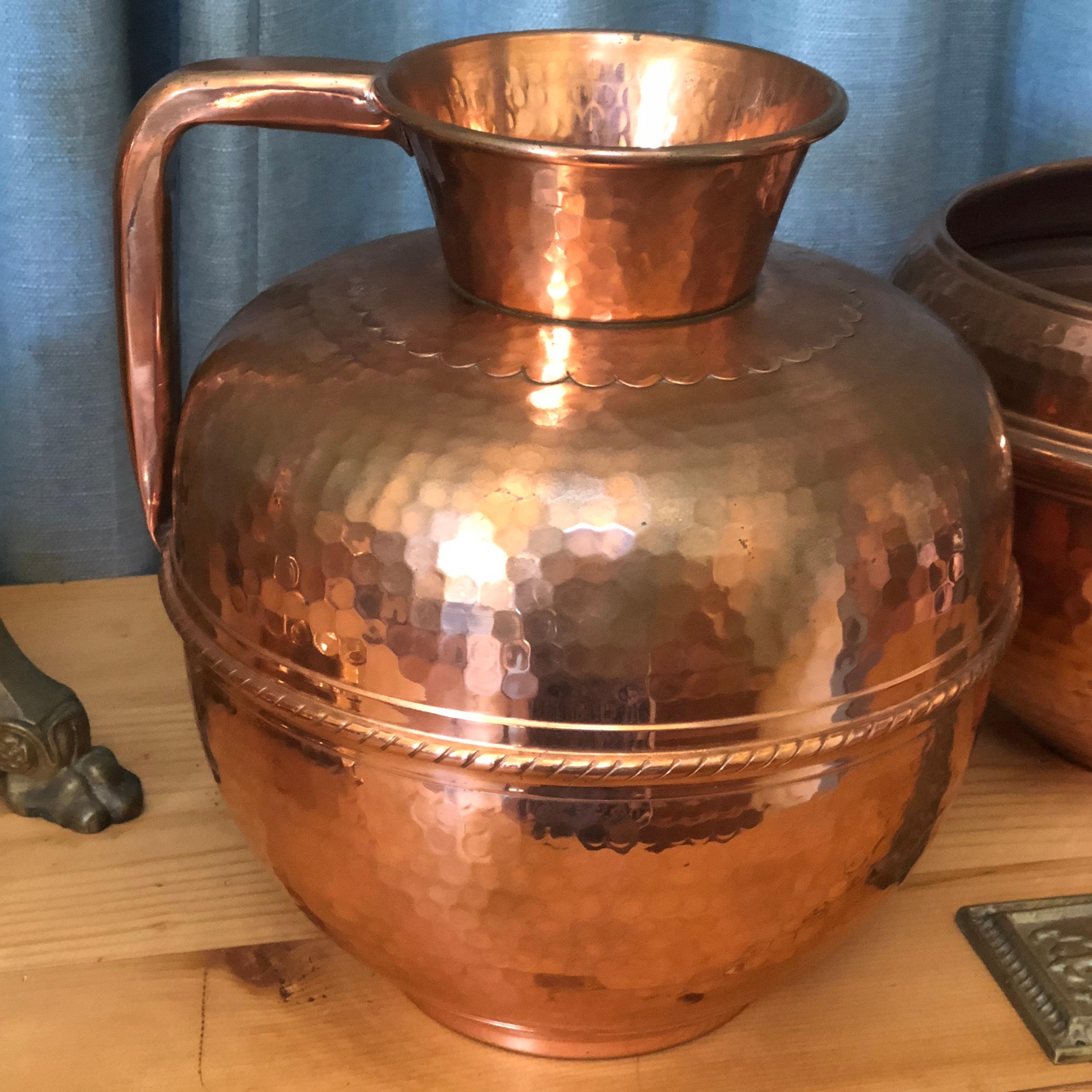 This exceptional condition French hammered copper pitcher, features a lovely plaited, handcrafted copper mid section, and large handle. The makers hallmark from France, is stamped on the base of the pitcher. This piece has a matching French hammered