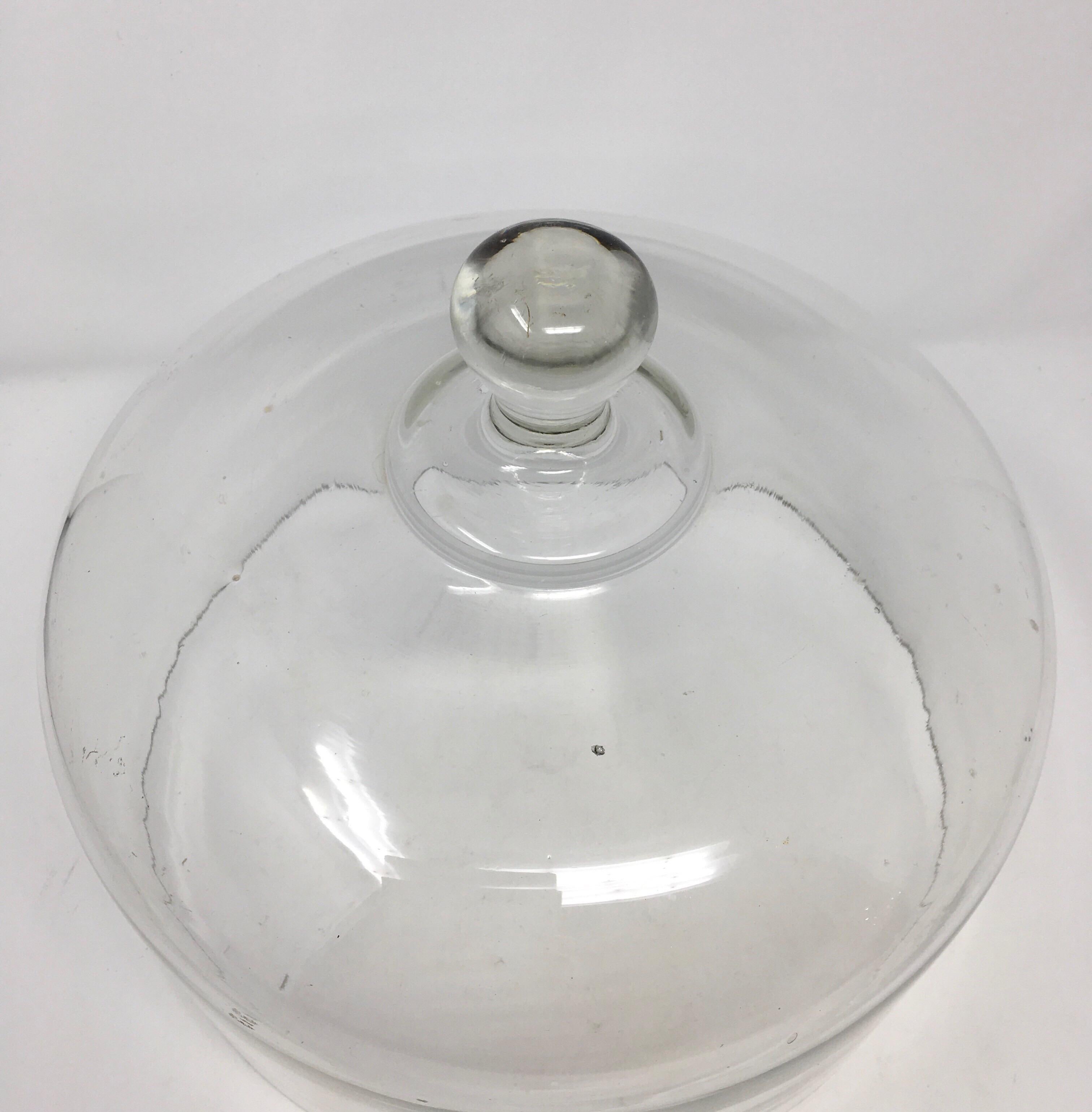 Found in France, this mid-19th century French hand blown glass cheese or pastry cloche is topped with a solid glass handle/knob. This charming hand blown dome has many bubbles and irregularities. Very decorative, could be used to cover food or