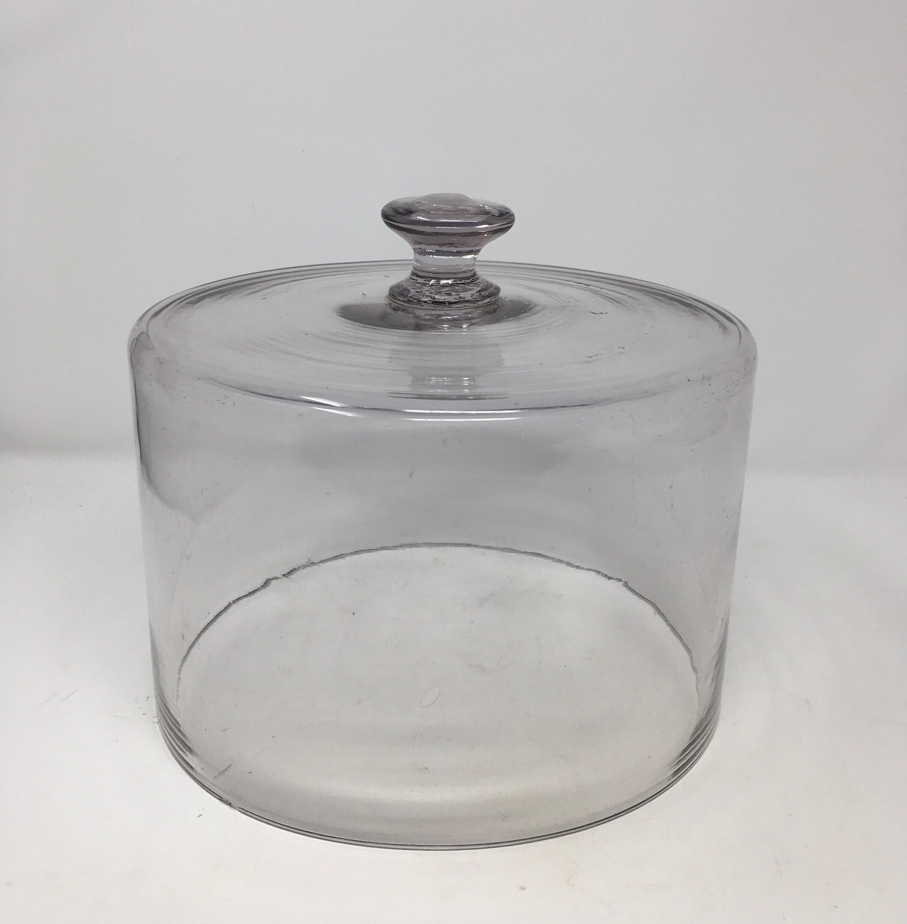 Found in France, this hand blown glass cheese or pastry cloche is topped with a solid glass handle/knob. This charming hand blown dome has many bubbles and irregularities. Very decorative, could be used to cover food or plants.