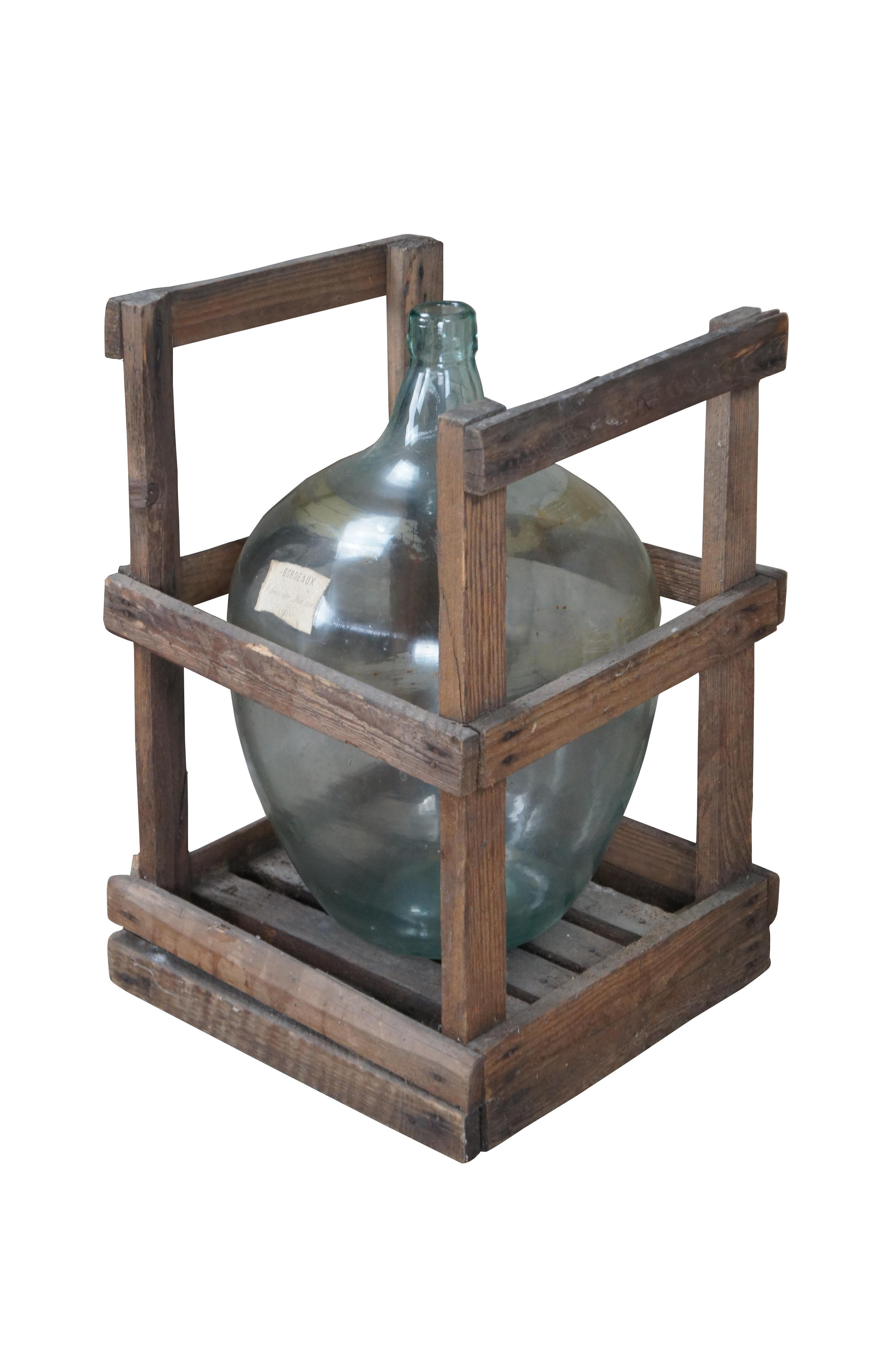 Antique French Hand Blown Glass Demijohn Bordeaux Wine Bottle Jug & Wood Crate. Features a pale green form and crate crafted from oak. Marked 1884

Dimensions:
15