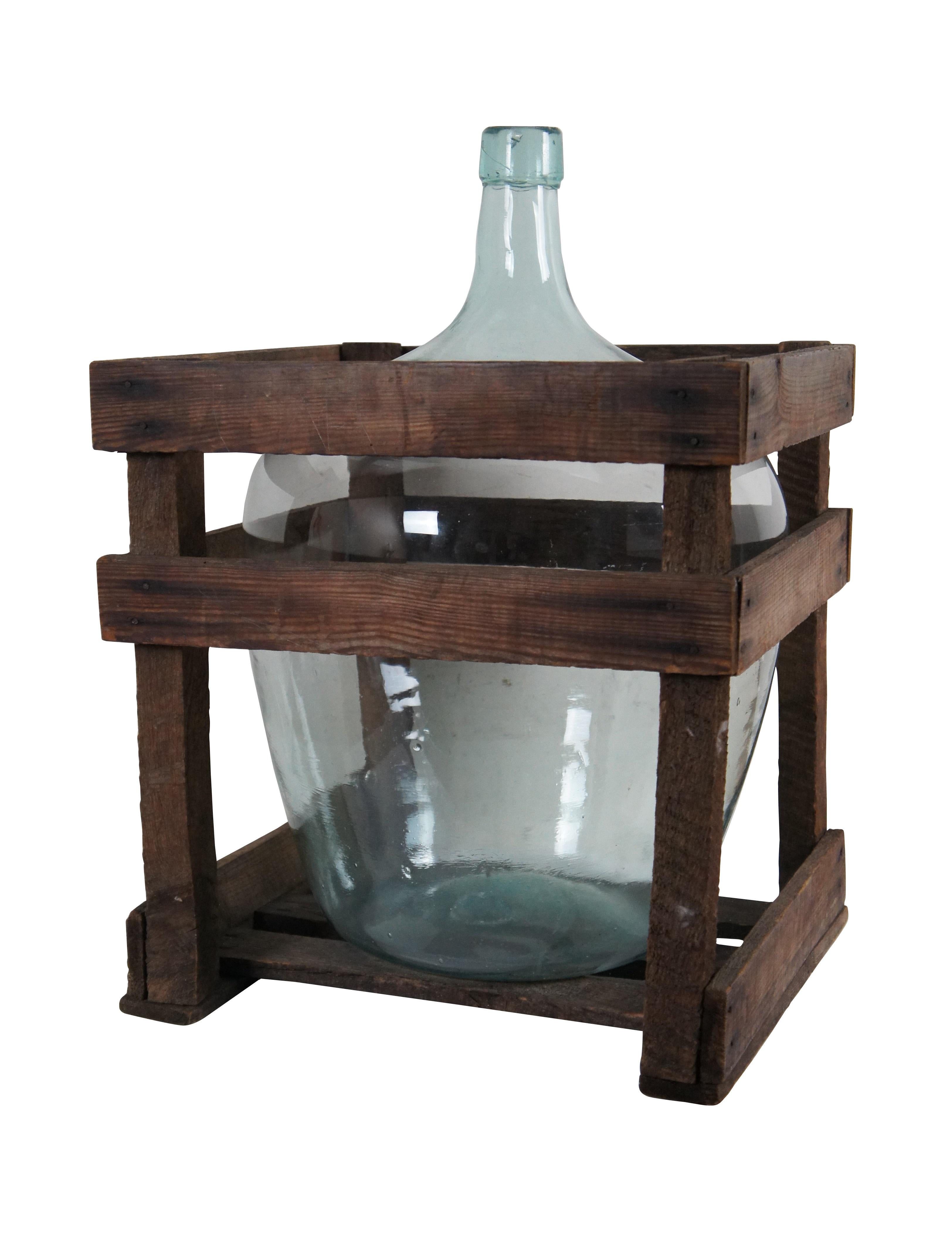Antique pale blue / clear glass demijohn wine bottle / jug and wood slat storage crate.

Dimensions:
Bottle - 14.5