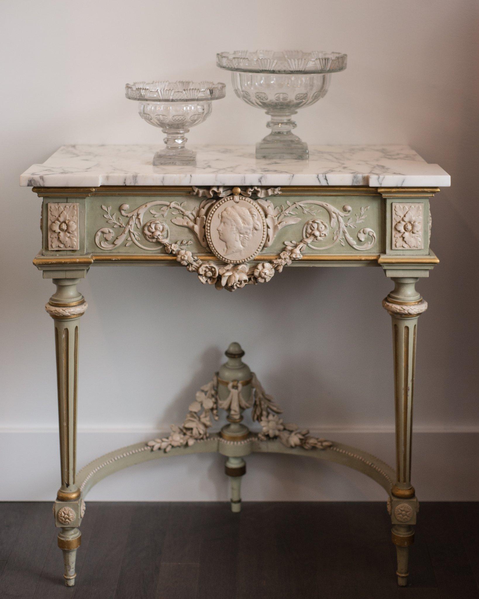 Imagine this stunning antique French console with a carved cameo in your entrance hall. In a small space this console could very easily become a bar. This Napoleon III console has been hand painted in crème and mint green which gives it an unusual