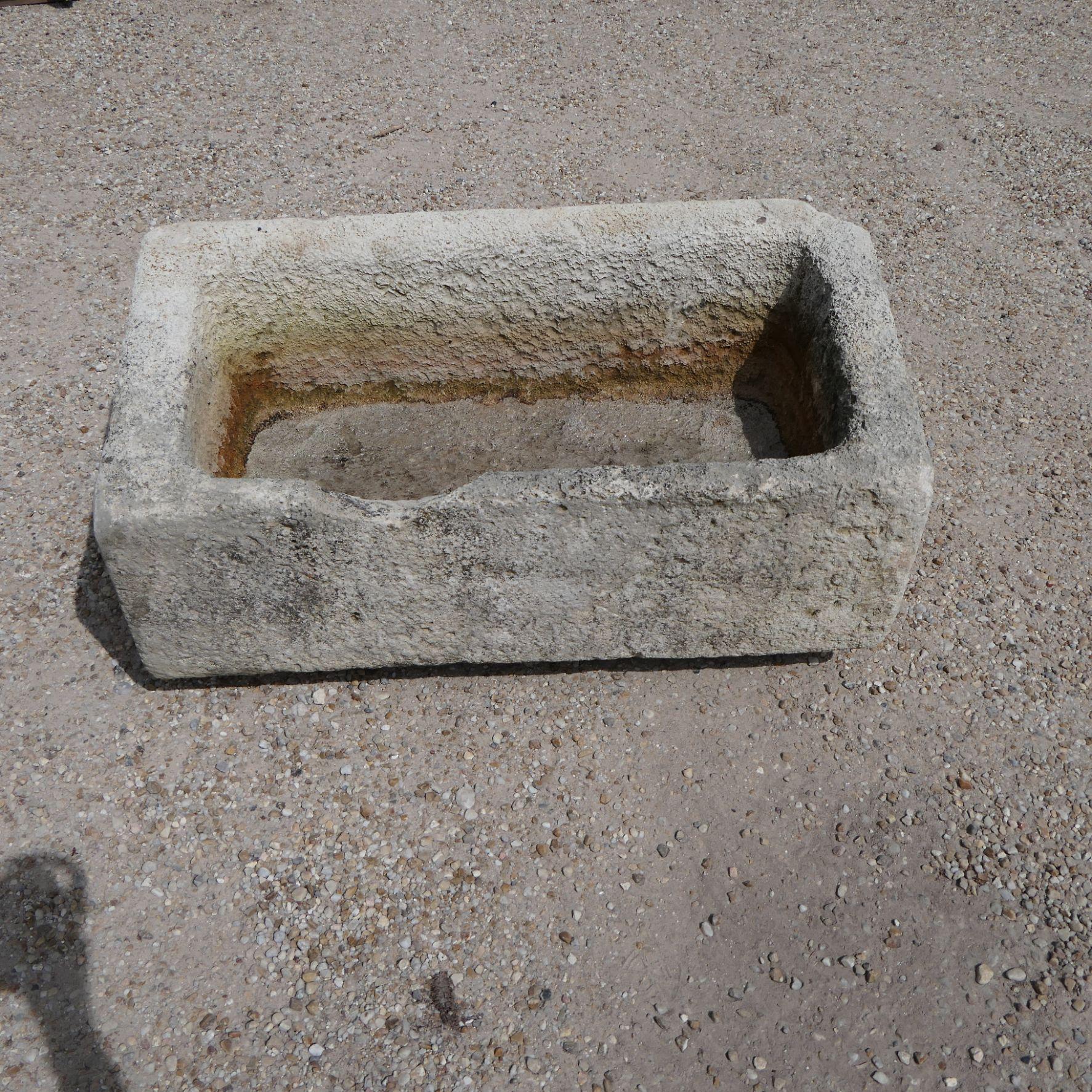 Un magnifico e autentico abbeveratoio antico, scolpito a mano da un unico e denso blocco di pietra calcarea francese nel XIX secolo. Questo pezzo è un notevole esempio di artigianato rustico, che in origine aveva uno scopo utilitario come bacino