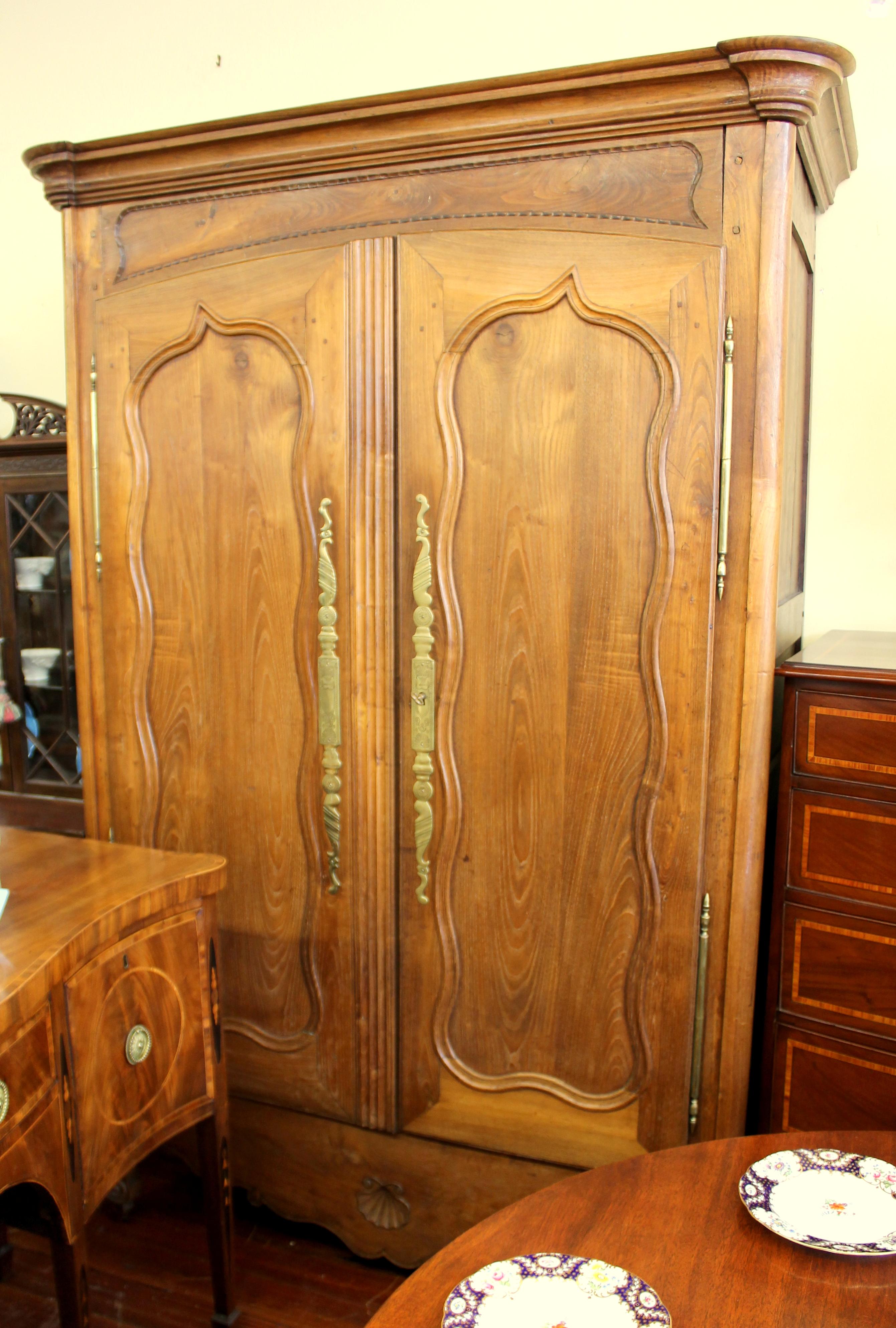 Fabulous quality antique French hand-carved Louis XV fruitwood armoire. Lovely honey colored, figured fruitwood.
Please note gorgeous, original chased brass hardware and carving throughout; toille paper inside. Interior shelves are removable.