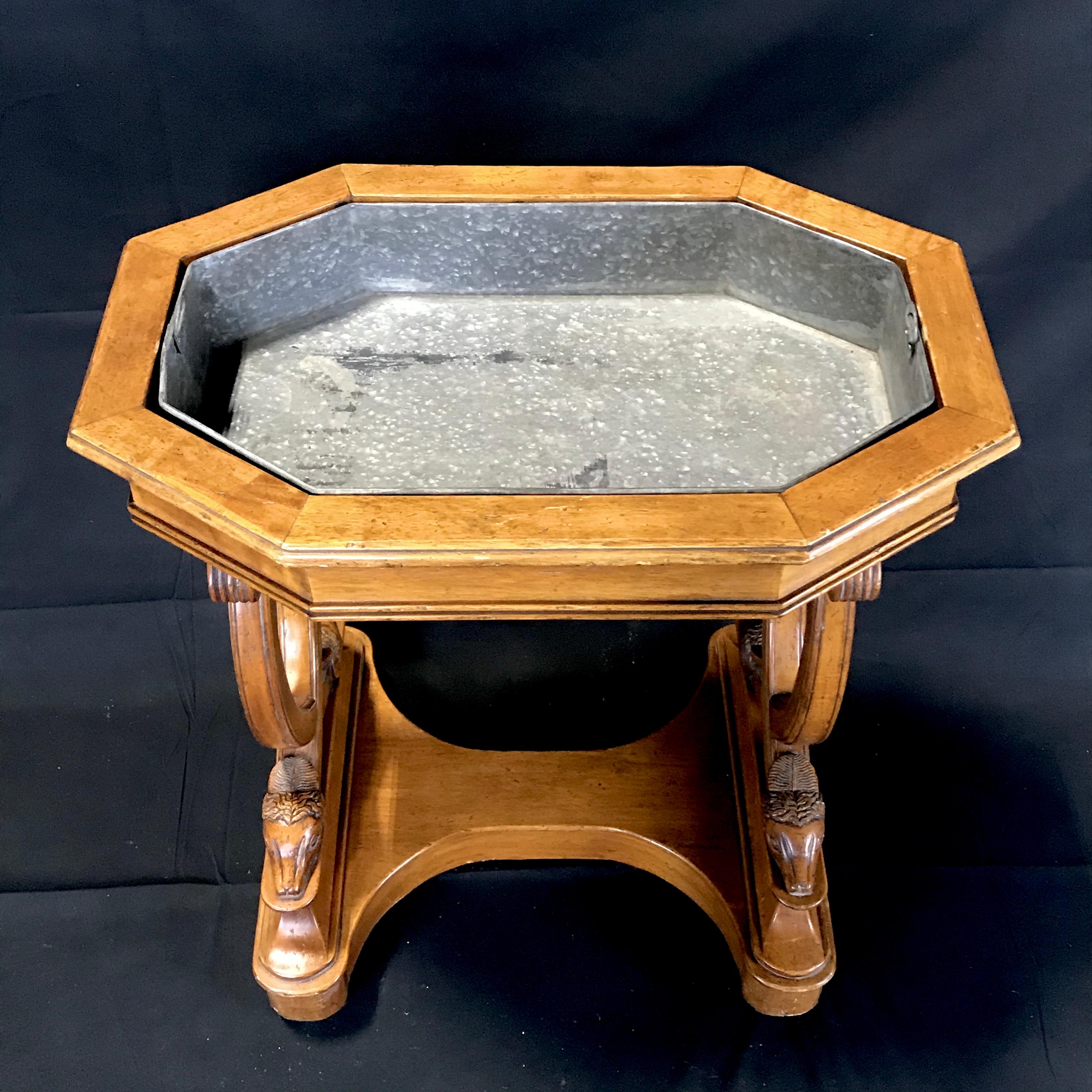 A late 19th century free standing French carved walnut planter table with incredible sheepshead figural feet. The removable zinc planter tray is inset into a boxed walnut top which tapers down to a decorative base highlighting the four exquisitely