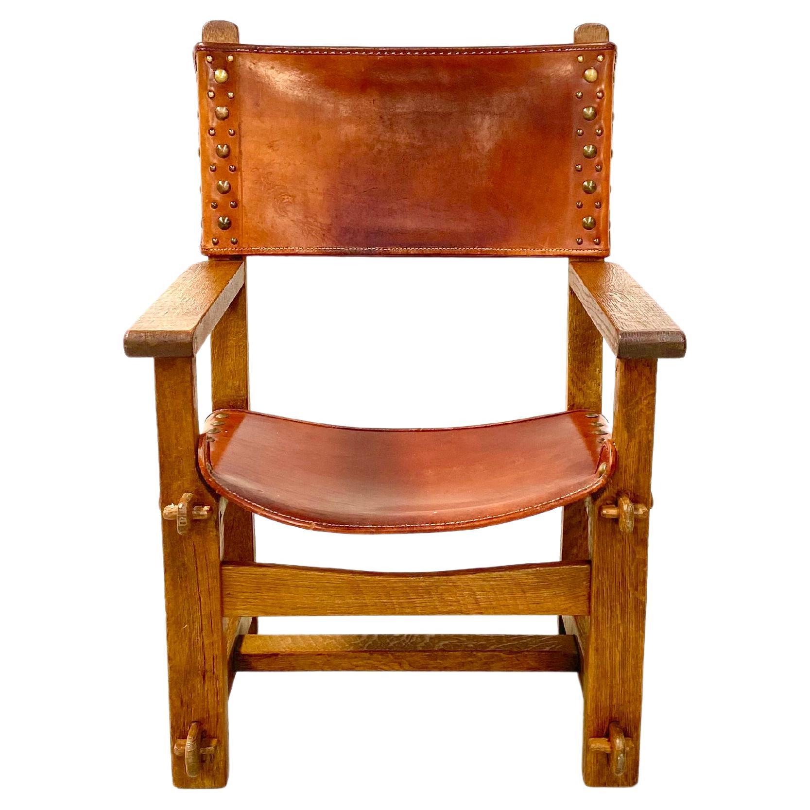 Antique Castle Chair in thick Cognac leather and oak wood. It was handmade in France in the late twenties. Handmade only from wood and leather. The patinated solid oak frame is handcrafted and the connections are made with wooden bobbins no nails or