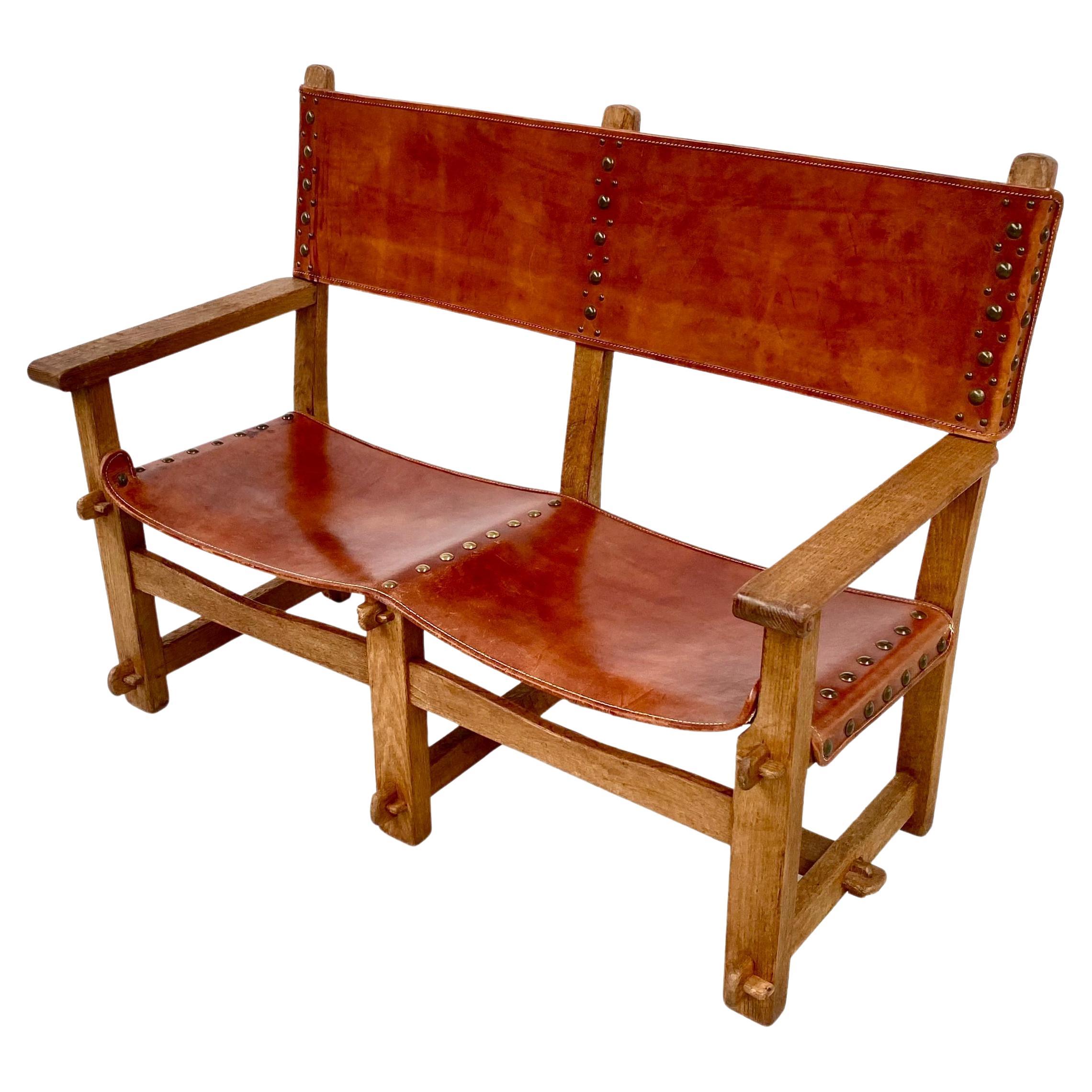 Antique Castle Bench in thick Cognac leather and oak wood. It was handmade in France in the late twenties. Handmade only from wood and leather. The patinated solid oak frame is handcrafted and the connections are made with wooden bobbins no nails or