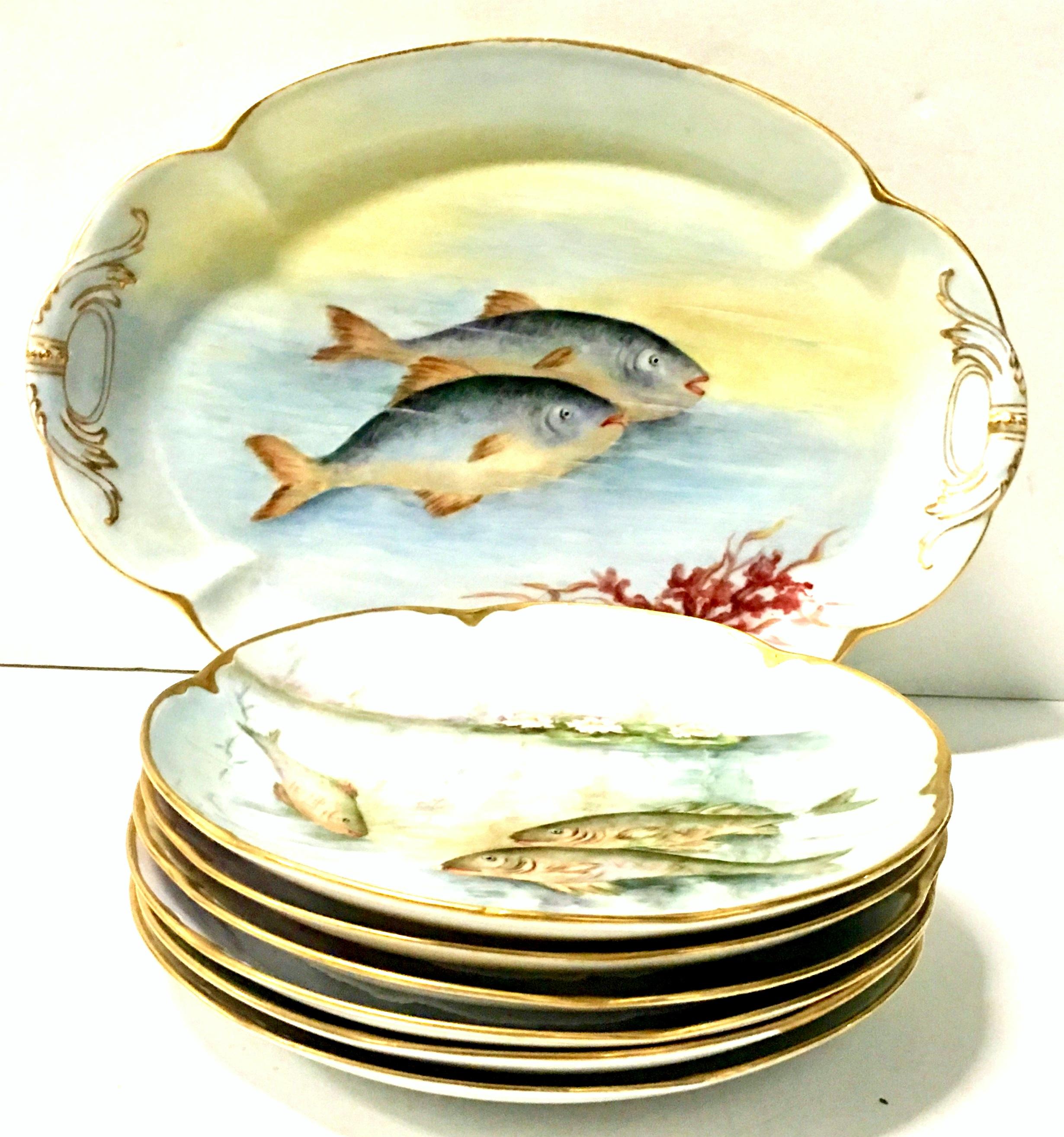 1890s Victorian Havliand Limoge & JHR Bavaria porcelain and 22-karat gold hand painted artist signed seven piece fish serving set. Stunning vibrant pastel hue set of seven fish serving porcelain plates and oval platter. Each piece depicts a